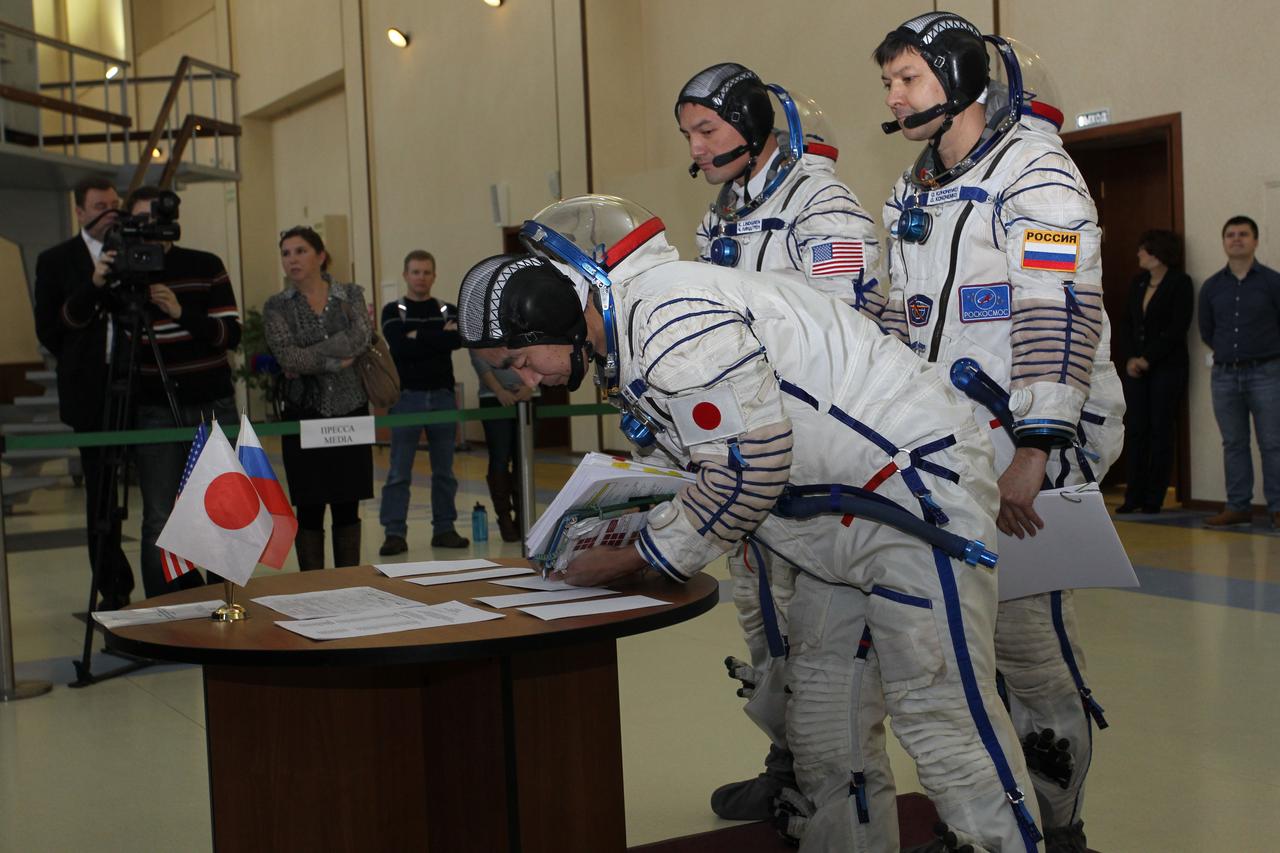 #3198 – (30 October 2014) --- At the Gagarin Cosmonaut Training Center in Star City, Russia, Expedition 42/43 backup crewmember Kimiya Yui of the Japan Aerospace Exploration Agency signs in for the first of two days of qualification exams October 30 as his crewmates, Kjell Lindgren of NASA and Oleg Kononenko of Roscosmos look on.  They are the backups to the prime crew --- Terry Virts of NASA, Anton Shkaplerov of Roscosmos and Samantha Cristoforetti of the European Space Agency --- who are in the final stages of training for launch November 24, Kazakh time, in the Soyuz TMA-15M spacecraft to begin a five and a half month mission on the International Space Station. Photo credit: NASA/Stephanie Stoll 