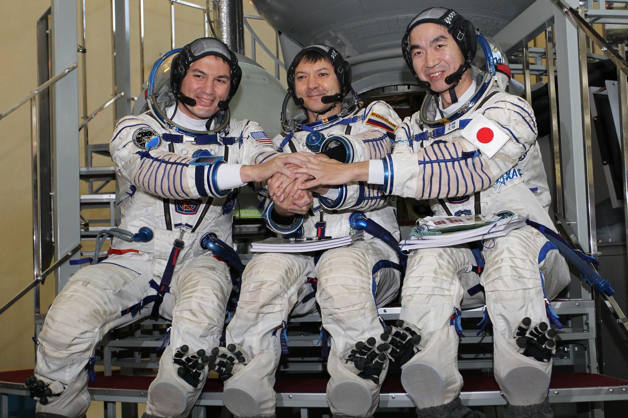 #3263 - (30 October 2014) --- At the Gagarin Cosmonaut Training Center in Star City, Russia, Expedition 42/43 backup crewmembers Kjell Lindgren of NASA (left), Soyuz Commander Oleg Kononenko of the Russian Federal Space Agency (Roscosmos, center) and Kimiya Yui of the Japan Aerospace Exploration Agency (right) pose for pictures in front of a Soyuz simulator October 30 as part of their final qualification exams for flight. They are the backups to the prime crew --- Terry Virts of NASA, Anton Shkaplerov of Roscosmos and Samantha Cristoforetti of the European Space Agency --- who are in the final stages of training for launch November 24, Kazakh time, in the Soyuz TMA-15M spacecraft to begin a five and a half month mission on the International Space Station. Photo credit: NASA/Stephanie Stoll