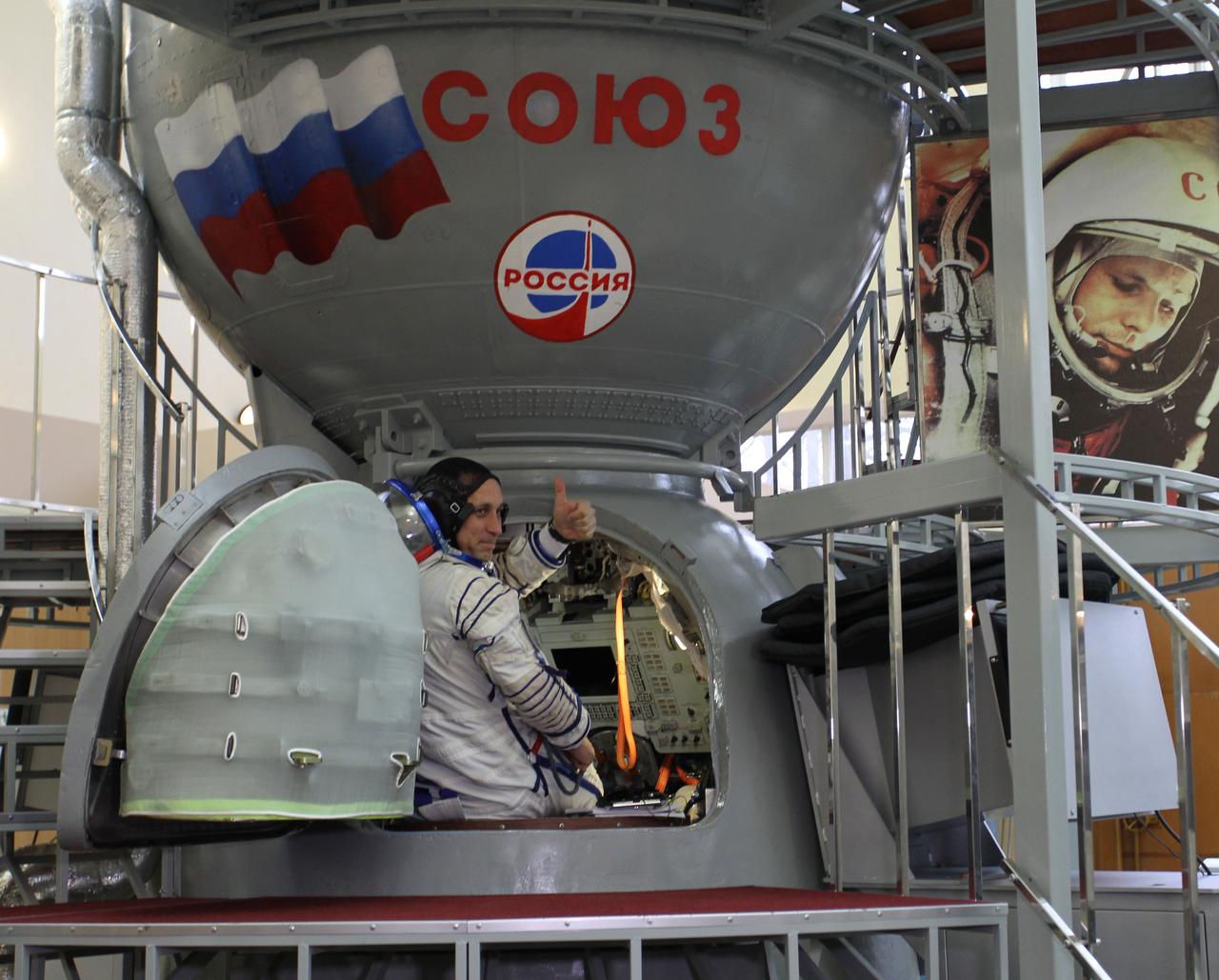 3608a:  At the Gagarin Cosmonaut Training Center in Star City, Russia, Expedition 42/43 Soyuz Commander Anton Shkaplerov of the Russian Federal Space Agency (Roscosmos) flashes a thumbs up as he enters a Soyuz simulator October 31 for the second day of qualification exams. Overlooking Shkaplerov is a wall mural depicting the image of Yuri Gagarin, the first human to fly in space. Shkaplerov, NASA Flight Engineer Terry Virts and European Space Agency Flight Engineer Samantha Cristoforetti are preparing for launch in the Soyuz TMA-15M spacecraft from the Baikonur Cosmodrome in Kazakhstan Nov. 24, Kazakh time, for a 5 ½ month mission on the International Space Station.  NASA/Stephanie Stoll 