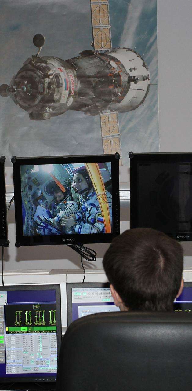 3630a:  At the Gagarin Cosmonaut Training Center in Star City, Russia, an instructor watches a television monitor showing the Expedition 42/43 crew running through their procedures in a Soyuz simulator during the second day of qualification exams October 31. NASA Flight Engineer Terry Virts, Soyuz Commander Anton Shkaplerov of the Russian Federal Space Agency (Roscosmos) and European Space Agency Flight Engineer Samantha Cristoforetti are preparing for launch in the Soyuz TMA-15M spacecraft from the Baikonur Cosmodrome in Kazakhstan Nov. 24, Kazakh time, for a 5 ½ month mission on the International Space Station.  NASA/Stephanie Stoll 