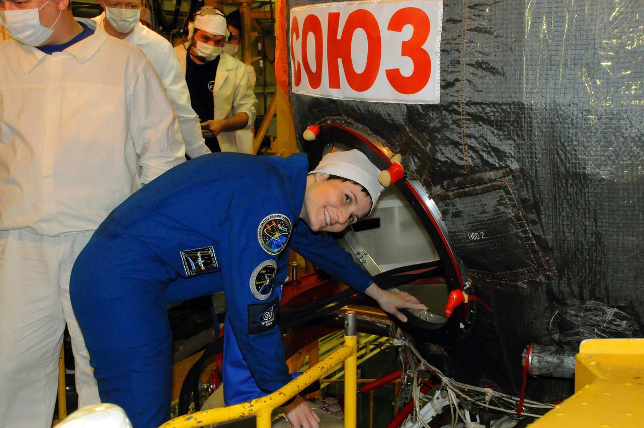 5293 copy OK:  In the Integration Facility at the Baikonur Cosmodrome in Kazakhstan, Expedition 42/43 crewmember Samantha Cristoforetti of the European Space Agency climbs into the Soyuz TMA-15M spacecraft during a “fit check” dress rehearsal Nov. 12. Cristoforetti, Terry Virts of NASA and Anton Shkaplerov of the Russian Federal Space Agency (Roscosmos) will launch Nov. 24, Kazakh time, from Baikonur for a 5 ½ month mission on the International Space Station.  NASA/Victor Ivanov 