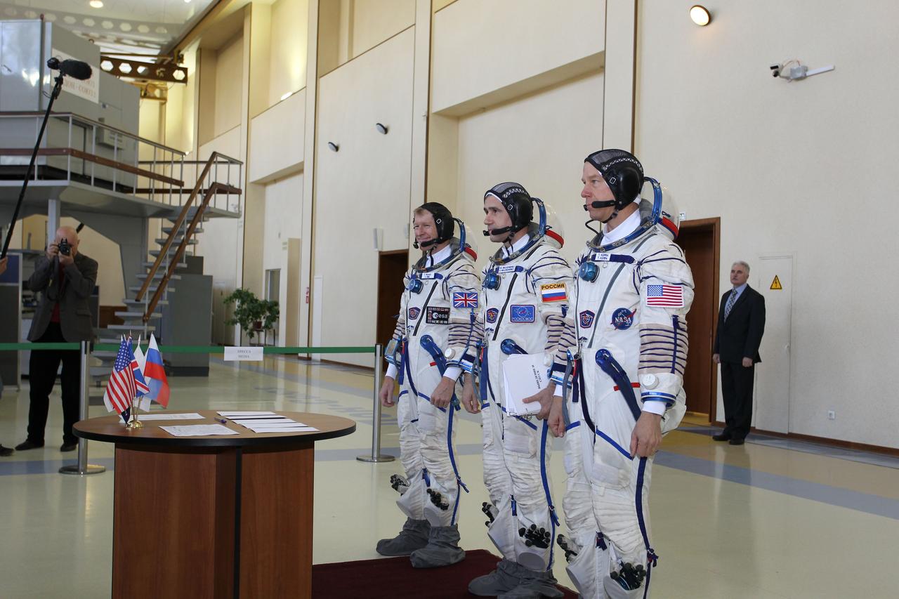 CG4G8713 --- (6 May 2015) --- At the Gagarin Cosmonaut Training Center in Star City, Russia, Expedition 44/45 backup Soyuz Commander Yuri Malenchenko of the Russian Federal Space Agency (Roscosmos, center) and his crewmates, Timothy Peake of the European Space Agency (left) and Timothy Kopra of NASA (right),  prepare to sign in for the first of two days of qualification exams. They are the backups to the prime crew --- Kjell Lindgren of NASA, Oleg Kononenko of Roscosmos and Kimya Yui of the Japan Aerospace Exploration Agency --- who are in the final stages of training for launch May 27, Kazakh time, in the Soyuz TMA-17M spacecraft to begin a five and a half month mission to the International Space Station. Photo credit: NASA/Seth Marcantel