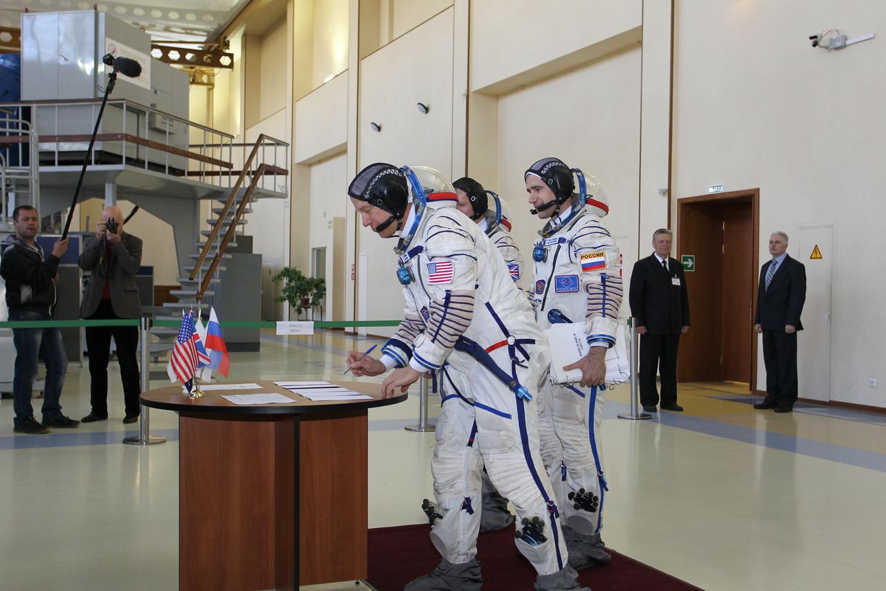 CG4G8721 --- (6 May 2015) --- At the Gagarin Cosmonaut Training Center in Star City, Russia, Expedition 44/45 backup Flight Engineer Timothy Kopra of NASA signs in for the first of two days of qualification exams May 6 as his crewmates, Yuri Malenchenko of the Russian Federal Space Agency (Roscosmos, center) and Timothy Peake of the European Space Agency (left) look on. They are the backups to the prime crew --- Kjell Lindgren of NASA, Oleg Kononenko of Roscosmos and Kimya Yui of the Japan Aerospace Exploration Agency --- who are in the final stages of training for launch May 27, Kazakh time, in the Soyuz TMA-17M spacecraft to begin a five and a half month mission to the International Space Station. Photo credit: NASA/Seth Marcantel