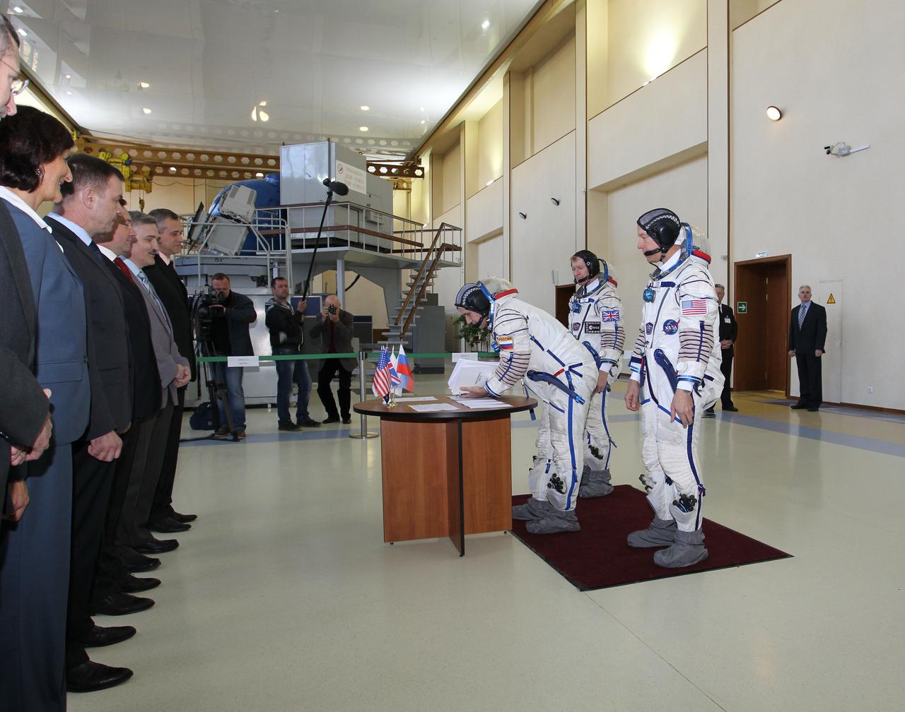 CG4G8740_1 --- (6 May 2015) --- At the Gagarin Cosmonaut Training Center in Star City, Russia, Expedition 44/45 backup Soyuz Commander Yuri Malenchenko of the Russian Federal Space Agency (Roscosmos) signs in for the first of two days of qualification exams May 6 as his crewmates, Timothy Peake of the European Space Agency (left) and Timothy Kopra of NASA (right) look on. They are the backups to the prime crew --- Kjell Lindgren of NASA, Oleg Kononenko of Roscosmos and Kimya Yui of the Japan Aerospace Exploration Agency --- who are in the final stages of training for launch May 27, Kazakh time, in the Soyuz TMA-17M spacecraft to begin a five and a half month mission to the International Space Station. Photo credit: NASA/Seth Marcantel