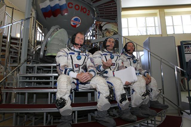 NASA image: CG4G8787  --- (6 May 2015) --- At the Gagarin Cosmonaut Training Center in Star City, Russia, Expedition 44/45 backup crewmembers Timothy Peake of the European Space Agency (left), Yuri Malenchenko of the Russian Federal Space Agency (Roscosmos, center) and Timothy Kopra of NASA (right) answer questions from reporters in front of a Soyuz spacecraft simulator May 6 as part of their final qualification exams for flight. They are the backups to the prime crew --- Kjell Lindgren of NASA, Oleg Kononenko of Roscosmos and Kimya Yui of the Japan Aerospace Exploration Agency --- who are in the final stages of training for launch May 27, Kazakh time, in the Soyuz TMA-17M spacecraft to begin a five and a half month mission to the International Space Station. Photo credit: NASA/Seth Marcantel