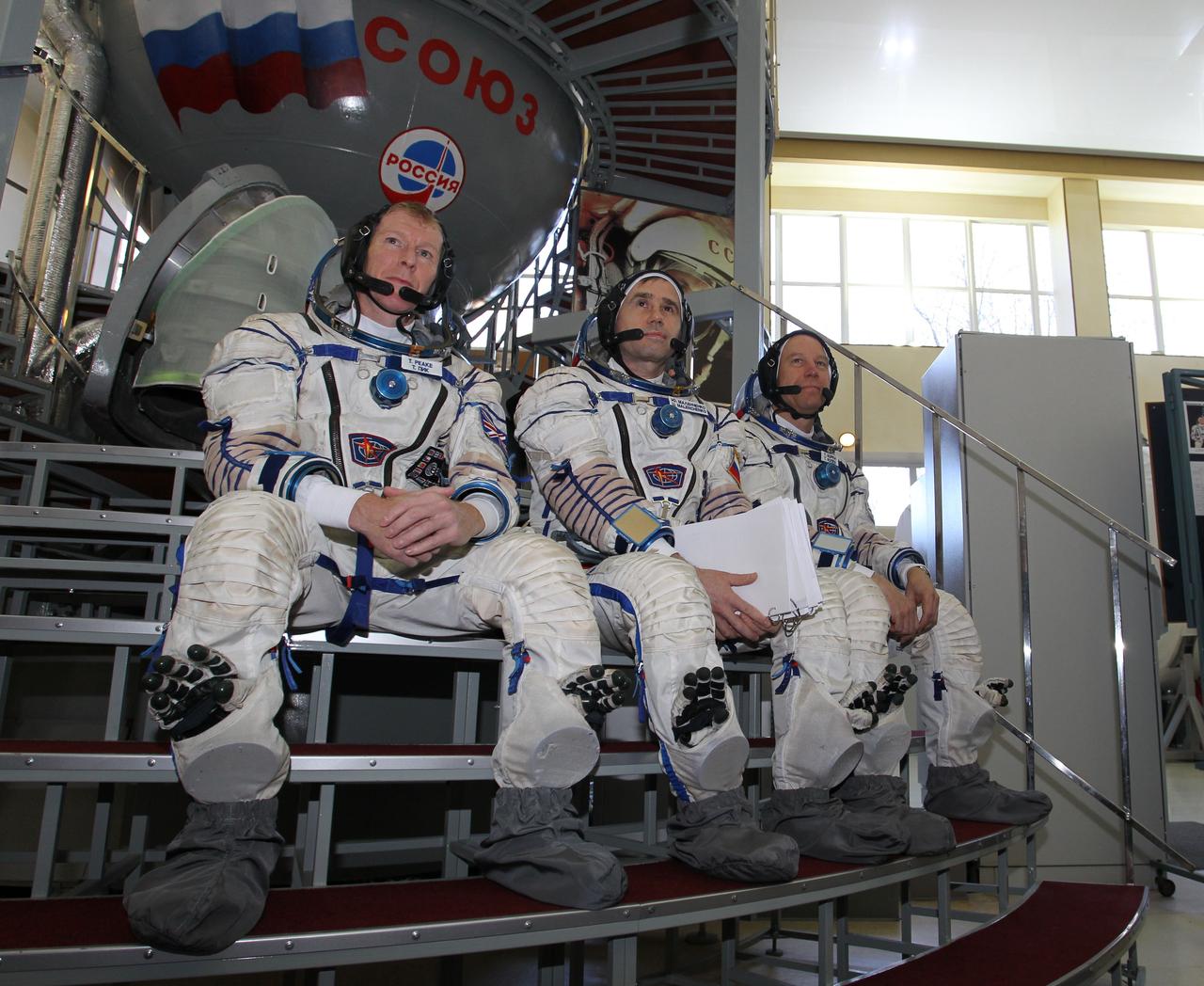 CG4G8796_1 --- (6 May 2015) --- At the Gagarin Cosmonaut Training Center in Star City, Russia, Expedition 44/45 backup crewmembers Timothy Peake of the European Space Agency (left), Yuri Malenchenko of the Russian Federal Space Agency (Roscosmos, center) and Timothy Kopra of NASA (right) answer questions from reporters in front of a Soyuz spacecraft simulator May 6 as part of their final qualification exams for flight. They are the backups to the prime crew --- Kjell Lindgren of NASA, Oleg Kononenko of Roscosmos and Kimya Yui of the Japan Aerospace Exploration Agency --- who are in the final stages of training for launch May 27, Kazakh time, in the Soyuz TMA-17M spacecraft to begin a five and a half month mission to the International Space Station. Photo credit: NASA/Seth Marcantel
