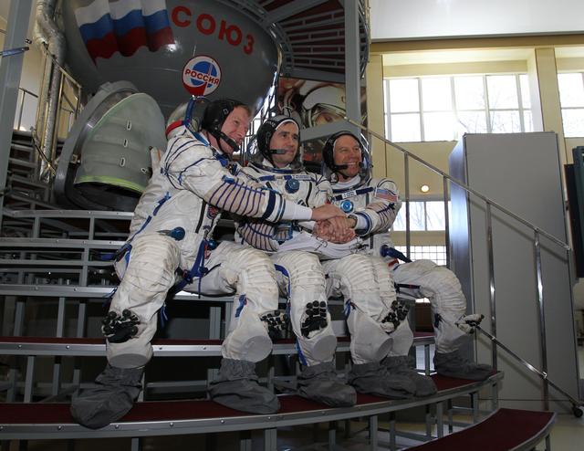 NASA image: CG4G8846_1 --- (6 May 2015) --- At the Gagarin Cosmonaut Training Center in Star City, Russia, Expedition 44/45 backup crewmembers Timothy Peake of the European Space Agency (left), Yuri Malenchenko of the Russian Federal Space Agency (Roscosmos, center) and Timothy Kopra of NASA (right) pose for pictures in front of a Soyuz spacecraft simulator May 6 as part of their final qualification exams for flight. They are the backups to the prime crew --- Kjell Lindgren of NASA, Oleg Kononenko of Roscosmos and Kimya Yui of the Japan Aerospace Exploration Agency --- who are in the final stages of training for launch May 27, Kazakh time, in the Soyuz TMA-17M spacecraft to begin a five and a half month mission to the International Space Station. Photo credit: NASA/Seth Marcantel