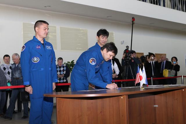 NASA image: CG4G8895 --- (6 May 2015) --- At the Gagarin Cosmonaut Training Center in Star City, Russia, Expedition 44/45 Soyuz Commander Oleg Kononenko of the Russian Federal Space Agency (Roscosmos) signs in for the first of two days of qualification exams May 6 as his crewmates, Kjell Lindgren of NASA (left) and Kimya Yui of the Japan Aerospace Exploration Agency (right), look on. The trio is preparing for launch from the Baikonur Cosmodrome in Kazakhstan on May 27, Kazakh time, in the Soyuz TMA-17M spacecraft to begin a five and a half month mission to the International Space Station. Photo credit: NASA/Seth Marcantel