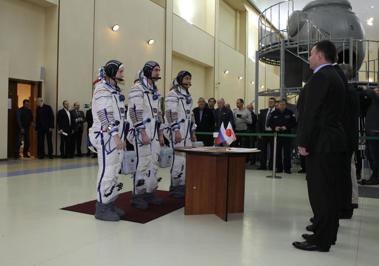 At the Gagarin Cosmonaut Training Center in Star City, Russia, Expedition 46-47 backup crewmembers Kate Rubins of NASA (left), Anatoly Ivanishin of the Russian Federal Space Agency (Roscosmos, center) and Takuya Onishi of the Japan Aerospace Exploration Agency (right) check in with Russian space officials Nov. 19 prior to their qualification exams. They are the backups to the prime crewmembers, Yuri Malenchenko of Roscosmos, Tim Kopra of NASA and Tim Peake of the European Space Agency, who will launch Dec. 15 in the Soyuz TMA-19M spacecraft from the Baikonur Cosmodrome in Kazakhstan for a six-month mission on the International Space Station. NASA/Seth Marcantel