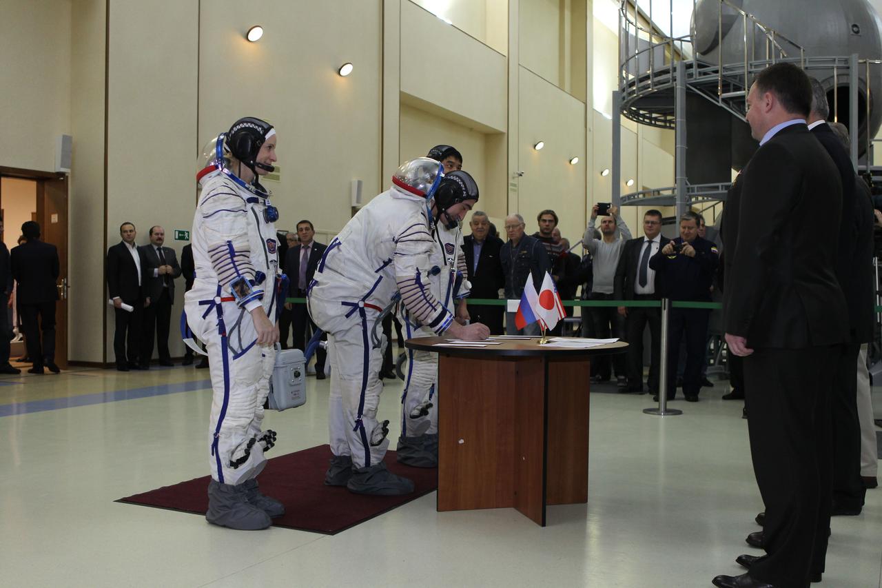 At the Gagarin Cosmonaut Training Center in Star City, Russia, Expedition 46-47 backup crewmember Anatoly Ivanishin of the Russian Federal Space Agency (Roscosmos) signs in Nov. 19 for the start of qualification exams as his crewmates, Kate Rubins of NASA (left) and Takuya Onishi of the Japan Aerospace Exploration Agency (right, behind Ivanishin) look on. They are the backups to the prime crewmembers, Yuri Malenchenko of Roscosmos, Tim Kopra of NASA and Tim Peake of the European Space Agency, who will launch Dec. 15 in the Soyuz TMA-19M spacecraft from the Baikonur Cosmodrome in Kazakhstan for a six-month mission on the International Space Station. NASA/Seth Marcantel