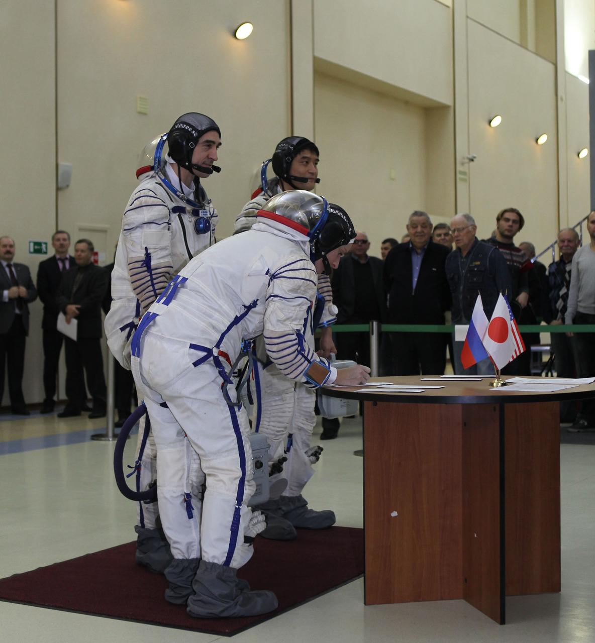 At the Gagarin Cosmonaut Training Center in Star City, Russia, Expedition 46-47 backup crewmember Kate Rubins of NASA signs in Nov. 19 for the start of qualification exams as her crewmates, Anatoly Ivanishin of the Russian Federal Space Agency (Roscosmos) and Takuya Onishi of the Japan Aerospace Exploration Agency look on. They are the backups to the prime crewmembers, Yuri Malenchenko of Roscosmos, Tim Kopra of NASA and Tim Peake of the European Space Agency, who will launch Dec. 15 in the Soyuz TMA-19M spacecraft from the Baikonur Cosmodrome in Kazakhstan for a six-month mission on the International Space Station. NASA/Seth Marcantel
