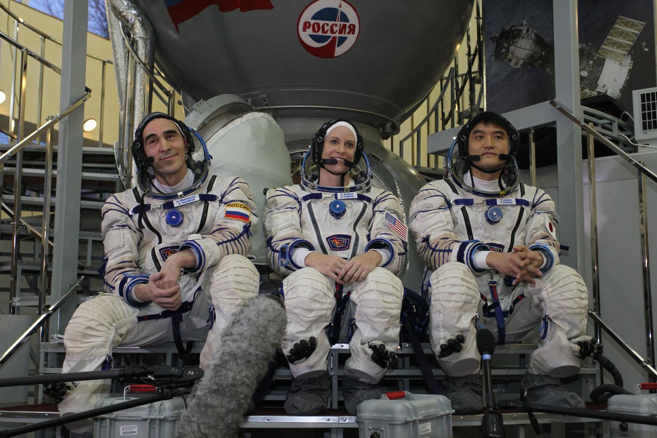 At the Gagarin Cosmonaut Training Center in Star City, Russia, Expedition 46-47 backup crewmembers Anatoly Ivanishin of the Russian Federal Space Agency (Roscosmos, left), Kate Rubins of NASA (center) and Takuya Onishi of the Japan Aerospace Exploration Agency (right) listen to reporters’ questions in front of a Soyuz simulator Nov. 19 at the start of qualification exams. They are the backups to the prime crewmembers, Yuri Malenchenko of Roscosmos, Tim Kopra of NASA and Tim Peake of the European Space Agency, who will launch Dec. 15 in the Soyuz TMA-19M spacecraft from the Baikonur Cosmodrome in Kazakhstan for a six-month mission on the International Space Station. NASA/Seth Marcantel