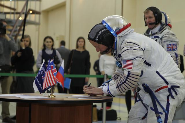 At the Gagarin Cosmonaut Training Center in Star City, Russia, Expedition 46-47 crewmember Tim Kopra of NASA signs in for his qualification exam Nov. 20 as his crewmate, Tim Peake of the European Space Agency looks on. Along with Yuri Malenchenko of the Russian Federal Space Agency (Roscosmos), Kopra and Peake will launch Dec. 15 on their Soyuz TMA-19M spacecraft Dec. 15 from the Baikonur Cosmodrome in Kazakhstan for a six-month mission on the International Space Station..NASA/Seth Marcantel