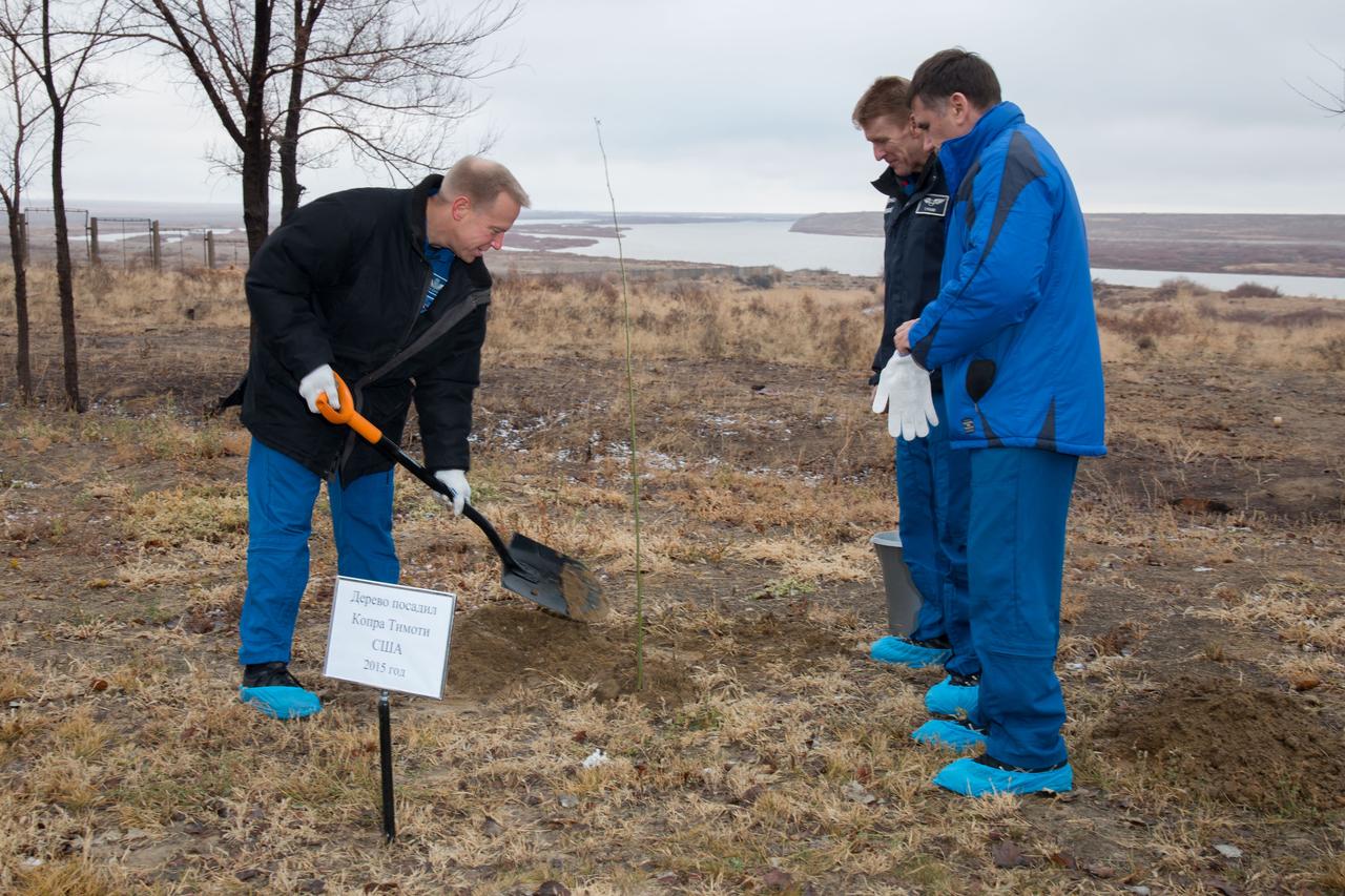 Behind the Cosmonaut Hotel crew quarters in Baikonur, Kazakhstan, Expedition 46-47 crewmember Tim Kopra of NASA (left) plants a tree at a site bearing his name Dec. 9 in a traditional pre-launch ceremony. Looking on are his crewmates, Tim Peake of the European Space Agency (center) and Yuri Malenchenko of the Russian Federal Space Agency (Roscosmos, right). The trio will launch Dec. 15 on their Soyuz TMA-19M spacecraft for a six-month mission on the International Space Station. NASA/Victor Zelentsov