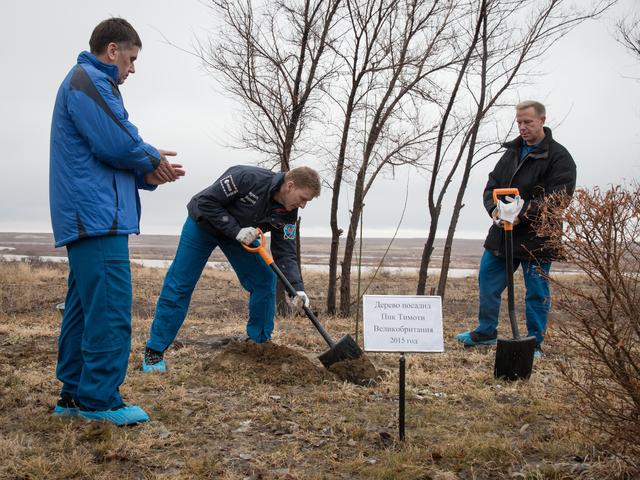 NASA image: Behind the Cosmonaut Hotel crew quarters in Baikonur, Kazakhstan, Expedition 46-47 crewmember Tim Peake of the European Space Agency (center) plants a tree at a site bearing his name Dec. 9 in a traditional pre-launch ceremony. Looking on are his crewmates, Yuri Malenchenko of the Russian Federal Space Agency (Roscosmos, left, and Tim Kopra of NASA (right). The trio will launch Dec. 15 on their Soyuz TMA-19M spacecraft for a six-month mission on the International Space Station...NASA/Victor Zelentsov.