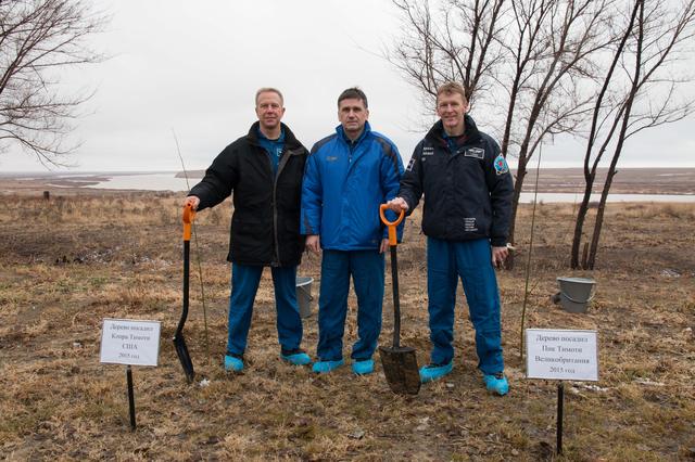 NASA image: Behind their Cosmonaut Hotel crew quarters in Baikonur, Kazakhstan, Expedition 46-47 crewmember Tim Kopra of NASA (left), Yuri Malenchenko of the Russian Federal Space Agency (Roscosmos, center) and Tim Peake of the European Space Agency (right) pose for pictures Dec. 9 after a traditional tree-planting ceremony. The trio will launch Dec. 15 on their Soyuz TMA-19M spacecraft for a six-month mission on the International Space Station...NASA/Victor Zelentsov.