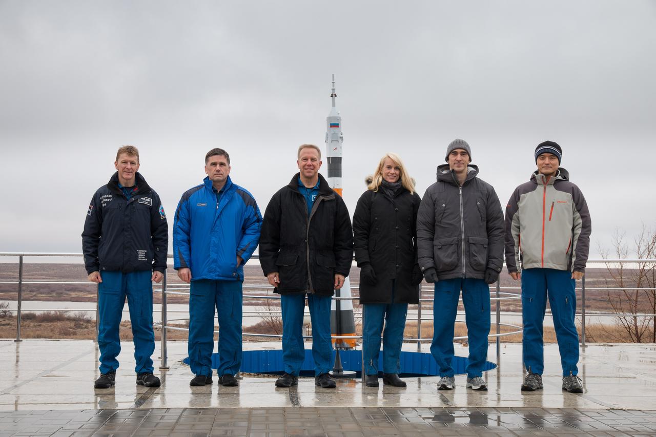 Behind their Cosmonaut Hotel crew quarters in Baikonur, Kazakhstan, the prime and backup Expedition 46-47 crewmembers pose for pictures Dec. 9 during a break in their training. From left to right are prime crewmembers Tim Peake of the European Space Agency, Yuri Malenchenko of the Russian Federal Space Agency and Tim Kopra of NASA, and backup crewmembers Kate Rubins of NASA, Anatoly Ivanishin of Roscosmos and Takuya Onishi of the Japan Aerospace Exploration Agency. Kopra, Peake and Malenchenko will launch Dec. 15 on their Soyuz TMA-19M spacecraft for a six-month mission on the International Space Station.  NASA/Victor Zelentsov 