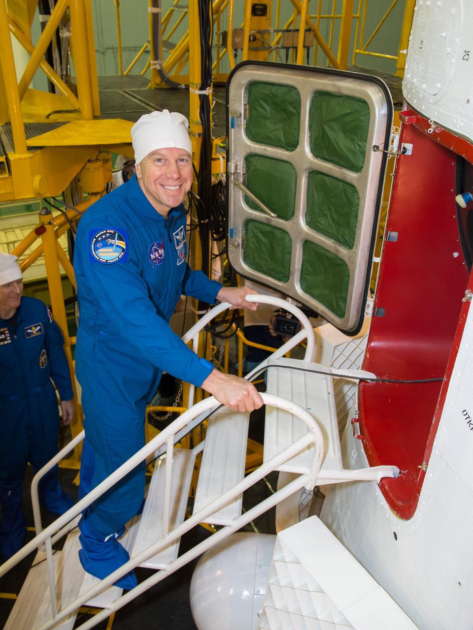 In the Integration Facility at the Baikonur Cosmodrome in Kazakhstan, Expedition 46-47 crewmember Tim Kopra of NASA flashes a smile before entering his Soyuz spacecraft Dec. 10 during a final fit check and inspection. Kopra, Tim Peake of the European Space Agency and Yuri Malenchenko of the Russian Federal Space Agency (Roscosmos) will launch Dec. 15 on the Soyuz TMA-19M spacecraft for a six-month mission on the International Space Station.  NASA/Victor Zelentsov 