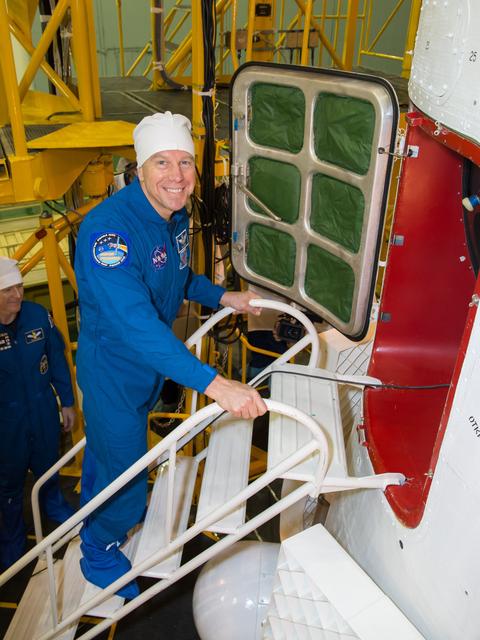 NASA image: In the Integration Facility at the Baikonur Cosmodrome in Kazakhstan, Expedition 46-47 crewmember Tim Kopra of NASA flashes a smile before entering his Soyuz spacecraft Dec. 10 during a final fit check and inspection. Kopra, Tim Peake of the European Space Agency and Yuri Malenchenko of the Russian Federal Space Agency (Roscosmos) will launch Dec. 15 on the Soyuz TMA-19M spacecraft for a six-month mission on the International Space Station...NASA/Victor Zelentsov.