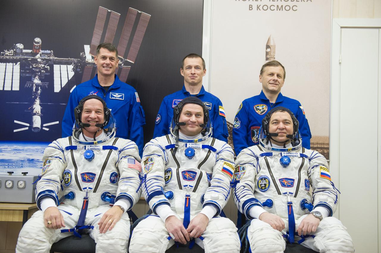 In the Integration Facility at the Baikonur Cosmodrome in Kazakhstan, the Expedition 47-48 prime and backup crewmembers pose for pictures March 4 during pre-launch training. In the front row in their Russian Sokol launch and entry suits are prime crewmembers Jeff Williams of NASA (left) and Alexey Ovchinin (center) and Oleg Skripochka (right) of Roscosmos. In the back row in flight suits are backup crewmembers Shane Kimbrough of NASA (left) and Sergey Ryzhikov (center) and Andre Borisenko (right) of Roscosmos. Williams, Ovchinin and Skripochka will launch March 19, Kazakh time, for a six-month mission on the International Space Station. Courtesy of Gagarin Cosmonaut Training Center