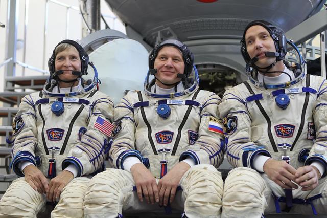 NASA image: At the Gagarin Cosmonaut Training Center in Star City, Russia, Expedition 48-49 backup crewmembers Peggy Whitson of NASA (left), Oleg Novitskiy of Roscosmos (center) and Thomas Pesquet of the European Space Agency (right) field questions from reporters in front of a Soyuz simulator during Soyuz qualification exams May 26. They are serving as the backups to prime crewmembers Kate Rubins of NASA, Takuya Onishi of the Japan Aerospace Exploration Agency and Anatoly Ivanishin of Roscosmos, who will launch June 24 on the Soyuz MS-01 spacecraft from the Baikonur Cosmodrome in Kazakhstan for a four-month mission on the International Space Station...NASA/Stephanie Stoll.