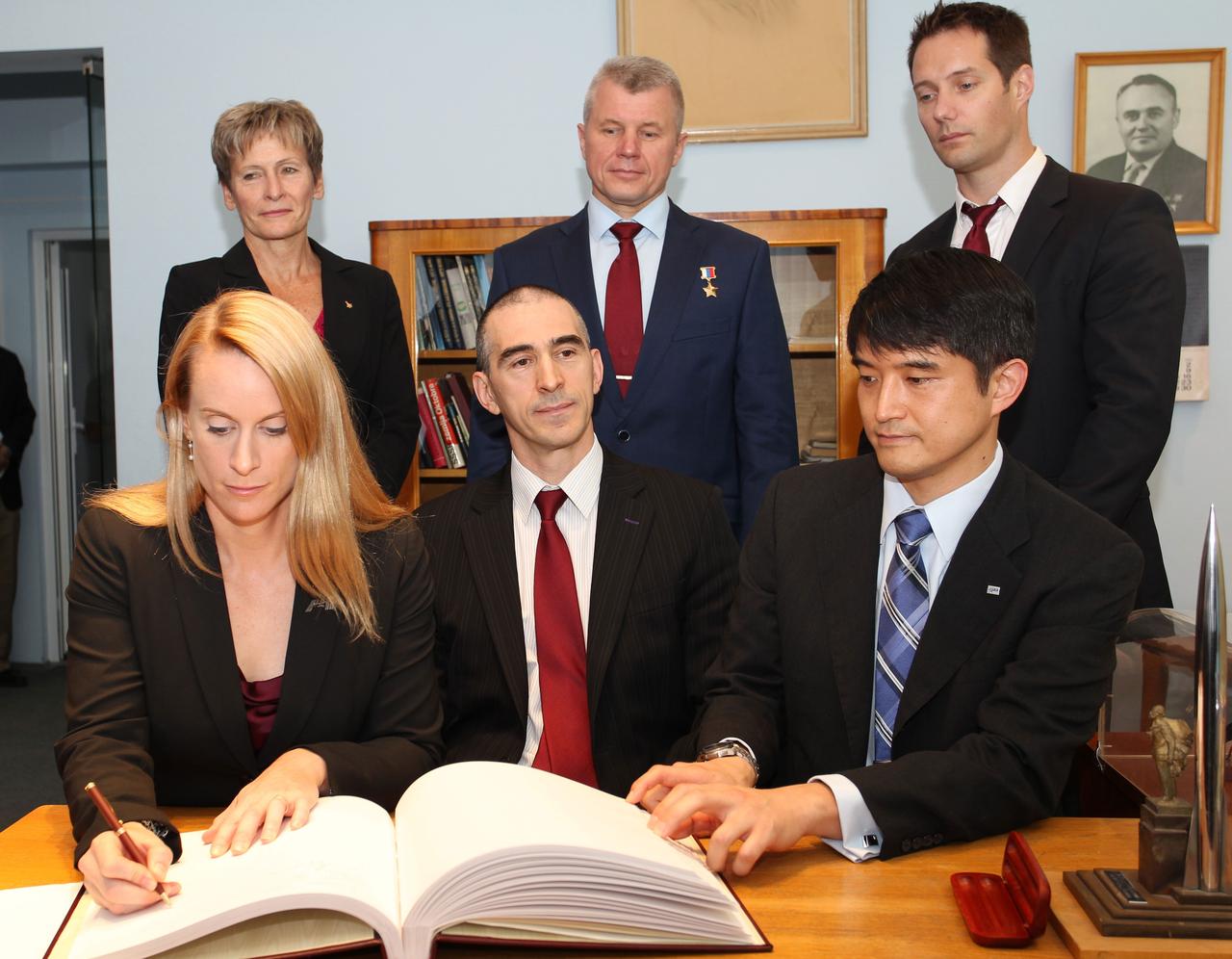 At the Gagarin Cosmonaut Training Center in Star City, Russia, Expedition 48-49 crewmember Kate Rubins of NASA (front row, left) signs a commemorative book May 31 following the crew’s news conference. Looking on are crewmates Anatoly Ivanishin of Roscosmos (front row, center) and Takuya Onishi of the Japan Aerospace Exploration Agency (front row, right). In the back row from left to right are backup crewmembers Peggy Whitson of NASA (left), Oleg Novitskiy of Roscosmos (center) and Thomas Pesquet of the European Space Agency (right). Rubins, Ivanishin and Onishi are scheduled to launch June 24 from the Baikonur Cosmodrome in Kazakhstan on the Soyuz MS-01 spacecraft for a four-month mission on the International Space Station.  NASA/Stephanie Stoll 