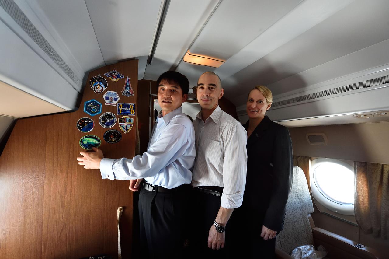 Aboard their aircraft on route to their launch site in Baikonur, Kazakhstan, ISS Expedition 48-49 crewmembers Takuya Onishi of the Japan Aerospace Exploration Agency (left), Anatoly Ivanishin of Roscosmos (center) and Kate Rubins of NASA (right) affix their mission insignia sticker to the wall June 24 after departing their training base in Star City, Russia. The trio will launch July 7 from the Baikonur Cosmodrome in Kazakhstan on the Soyuz MS-01 spacecraft for a planned four-month mission on the International Space Station.  NASA/Alexander Vysotsky 