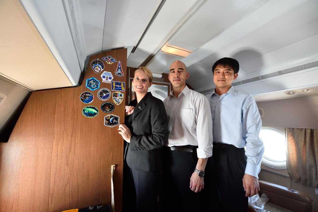 Aboard their aircraft en route to their launch site in Baikonur, Kazakhstan, ISS Expedition 48-49 crewmembers Kate Rubins of NASA (left), Anatoly Ivanishin of Roscosmos (center) and Takuya Onishi of the Japan Aerospace Exploration Agency (right) pose for pictures after affixing their mission insignia stickers to the wall June 24 following their departure from their training base in Star City, Russia. The trio will launch July 7 from the Baikonur Cosmodrome in Kazakhstan on the Soyuz MS-01 spacecraft for a planned four-month mission on the International Space Station.  NASA/Alexander Vysotsky 