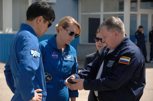 NASA image: Outside the Integration Facility at the Baikonur Cosmodrome in Kazakhstan, Expedition 48-49 crewmembers Takuya Onishi of the Japan Aerospace Exploration Agency (left) and Kate Rubins of NASA (second from left) receive a briefing on the use of a satellite phone June 25 as they prepare for their launch with Anatoly Ivanishin of Roscosmos on July 7, Baikonur time, on the Soyuz MS-01 spacecraft for a planned four-month mission on the International Space Station...NASA/Alexander Vysotsky.