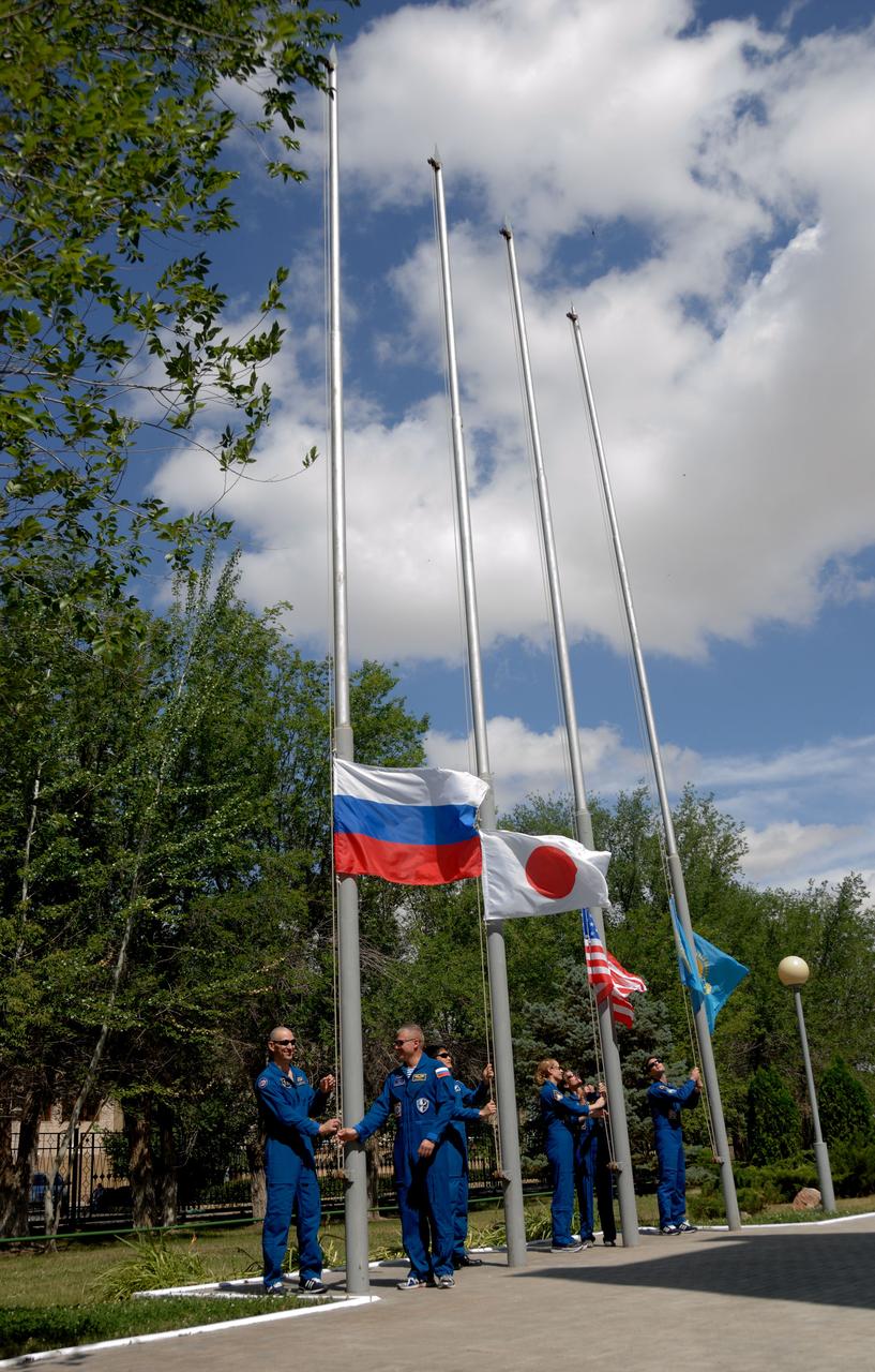Outside their Cosmonaut Hotel crew quarters in Baikonur, Kazakhstan, the Expedition 48-49 prime and backup crewmembers conduct the traditional raising of the Russian, Japanese, American and Kazakh flags June 26. Prime crewmembers Kate Rubins of NASA, Anatoly Ivanishin of Roscosmos and Takuya Onishi of the Japan Aerospace Exploration Agency will launch on July 7, Baikonur time, on the Soyuz MS-01 spacecraft for a planned four-month mission on the International Space Station.  NASA/Alexander Vysotsky 