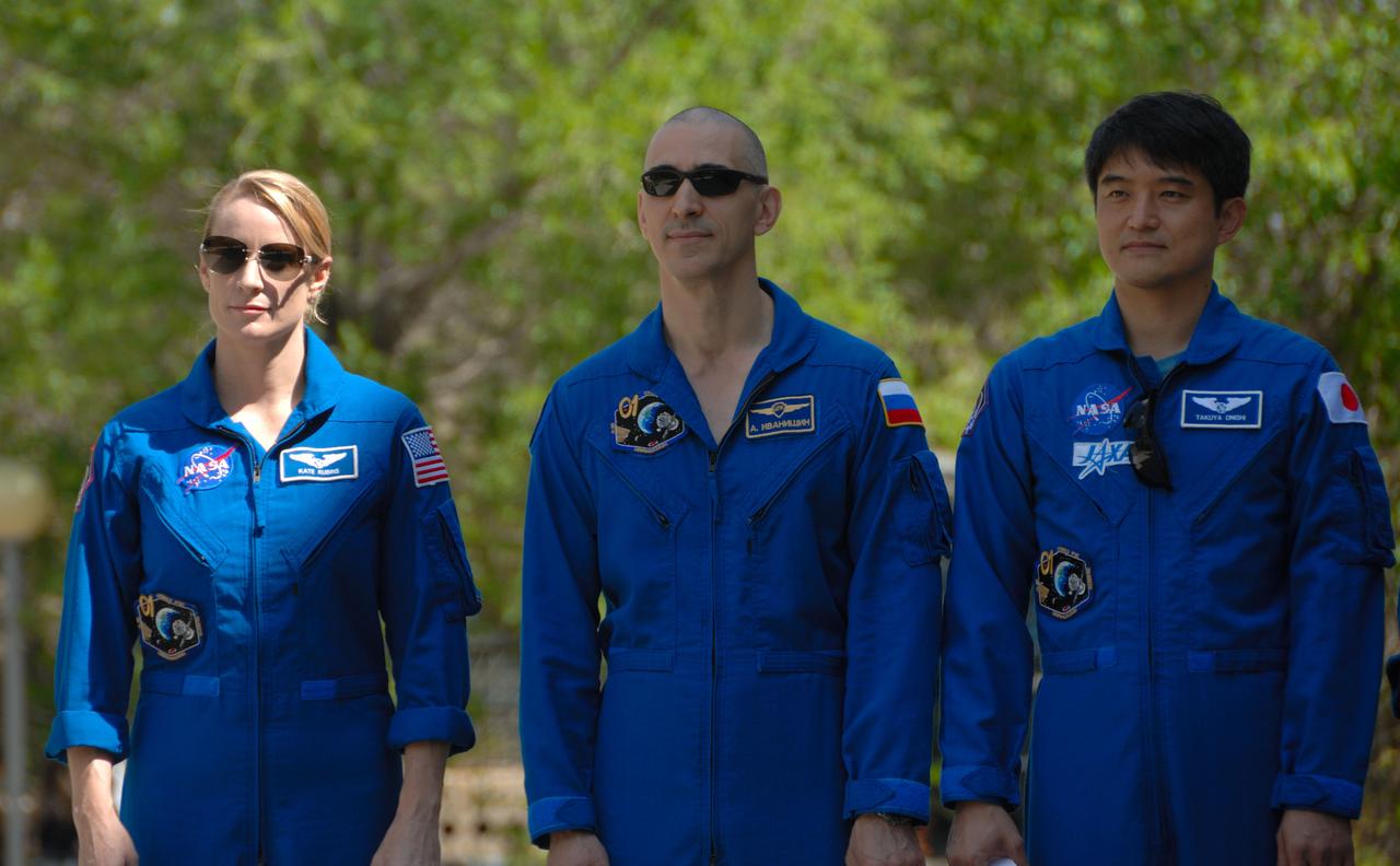 Outside their Cosmonaut Hotel crew quarters in Baikonur, Kazakhstan, Expedition 48-49 crewmembers Kate Rubins of NASA (left), Anatoly Ivanishin of Roscosmos (center) and Takuya Onishi of the Japan Aerospace Exploration Agency (right) listen to remarks June 26 during the traditional raising of the American, Russian, Japanese and Kazakh flags. The trio will launch on July 7, Baikonur time, on the Soyuz MS-01 spacecraft for a planned four-month mission on the International Space Station.  NASA/Alexander Vysotsky 