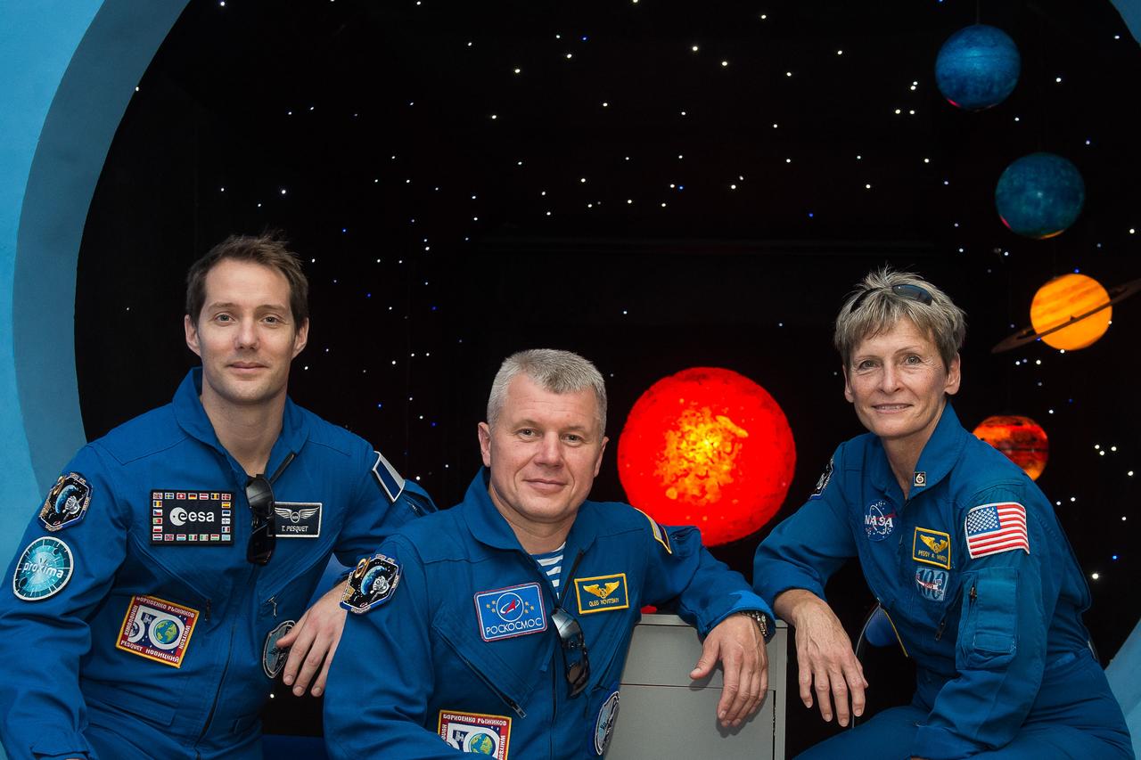 During a tour of a museum in Baikonur, Kazakhstan June 26, Expedition 48-49 backup crewmembers Thomas Pesquet of the European Space Agency (left), Oleg Novitskiy of Roscosmos (center) and Peggy Whitson of NASA (right) pose for pictures in front of a mural depicting planets. Whitson, Novitskiy and Pesquet are backups to Kate Rubins of NASA, Anatoly Ivanishin of Roscosmos and Takuya Onishi of the Japan Aerospace Exploration Agency, who are preparing for launch on July 7, Baikonur time, on the Soyuz MS-01 spacecraft for a planned four-month mission on the International Space Station.  GCTC/Andrei Shelepin 