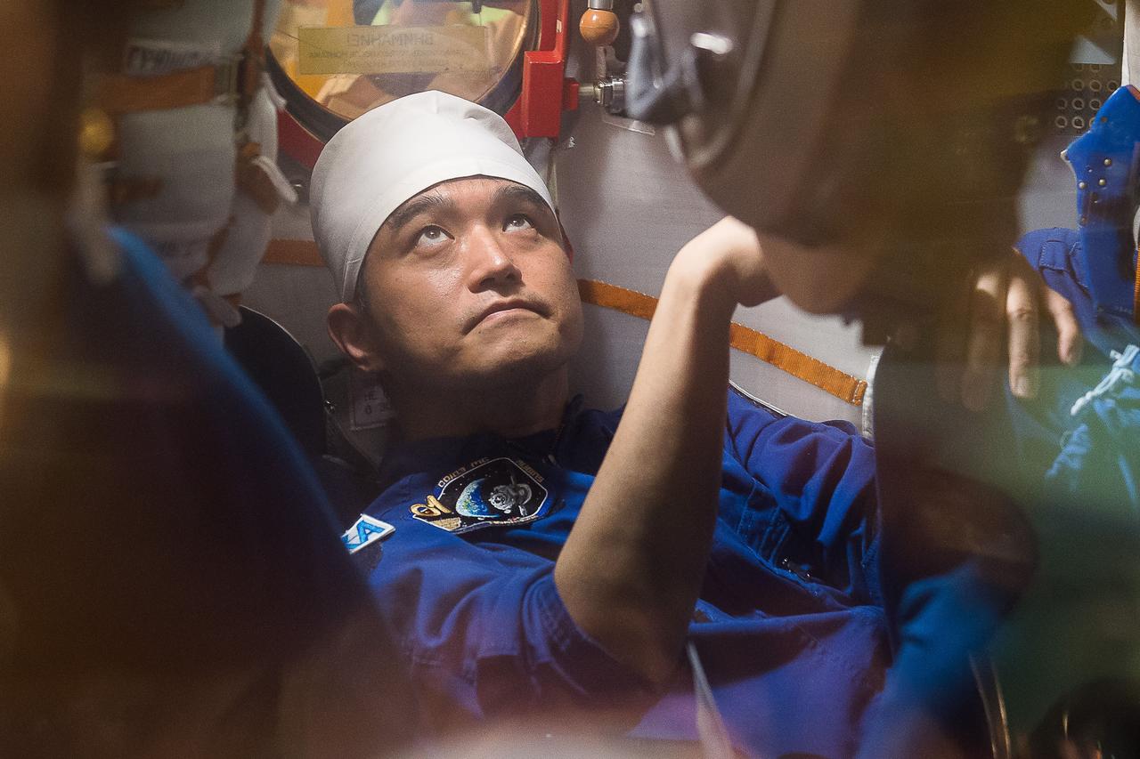 In the Integration Facility at the Baikonur Cosmodrome in Kazakhstan, Expedition 48-49 crewmember Takuya Onishi of the Japan Aerospace Exploration Agency conducts a “fit check” familiarization aboard the Soyuz MS-01 spacecraft June 25 as part of the preparations for launch with Anatoly Ivanishin of Roscosmos and Kate Rubins of NASA on July 7, Baikonur time for a planned four-month mission on the International Space Station.  GCTC/Andrei Shelepin 