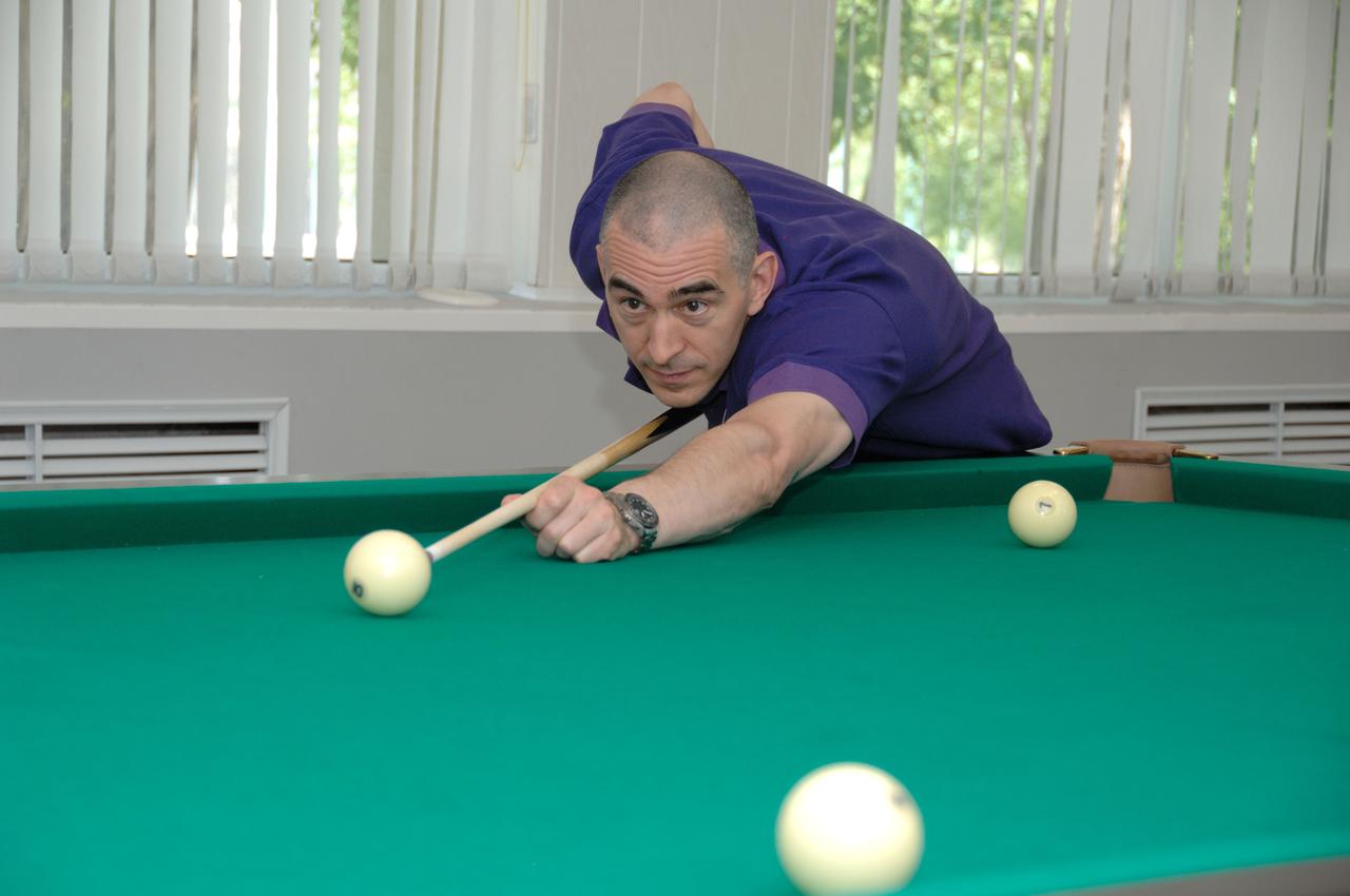 At the Cosmonaut Hotel in Baikonur, Kazakhstan, Expedition 48-49 crewmember Anatoly Ivanishin of Roscosmos tries his hand a billiards June 30 during pre-launch activities. Ivanishin, Takuya Onishi of the Japan Aerospace Exploration Agency and Kate Rubins of NASA will launch July 7, Baikonur time, on the Soyuz MS-01 spacecraft for a planned four-month mission on the International Space Station.  NASA/Alexander Vysotsky 