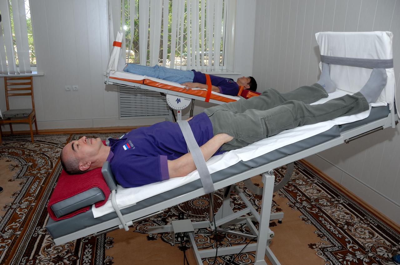 At the Cosmonaut Hotel in Baikonur, Kazakhstan, Expedition 48-49 crewmembers Anatoly Ivanishin of Roscosmos (foreground) and Takuya Onishi of the Japan Aerospace Exploration Agency conduct tests of their vestibular system on tilt tables June 30 as part of pre-launch activities. They and Kate Rubins of NASA will launch July 7, Baikonur time, on the Soyuz MS-01 spacecraft for a planned four-month mission on the International Space Station.  NASA/Alexander Vysotsky 