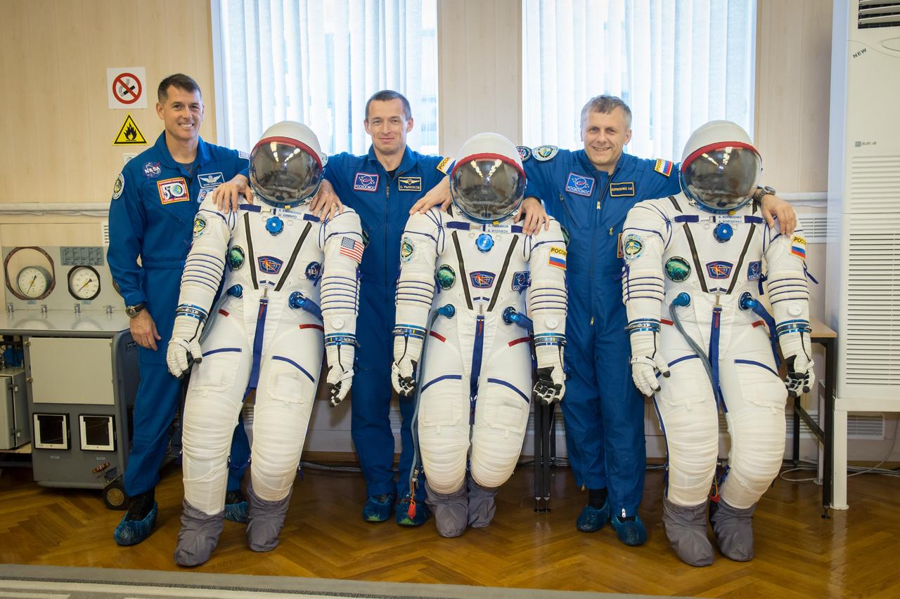 At the Integration Facility at the Baikonur Cosmodrome in Kazakhstan, Expedition 49 crewmembers Shane Kimbrough of NASA (left) and Sergey Ryzhikov (center) and Andrey Borisenko (right) of Roscosmos share a light-hearted moment Sept. 9 as they pose for pictures with their Sokol launch and entry suits during a pre-launch training fit check. Kimbrough, Ryzhikov and Borisenko will launch Sept. 24, Kazakh time on the Soyuz MS-02 vehicle for a five-month mission on the International Space Station.  NASA/Victor Zelentsov 