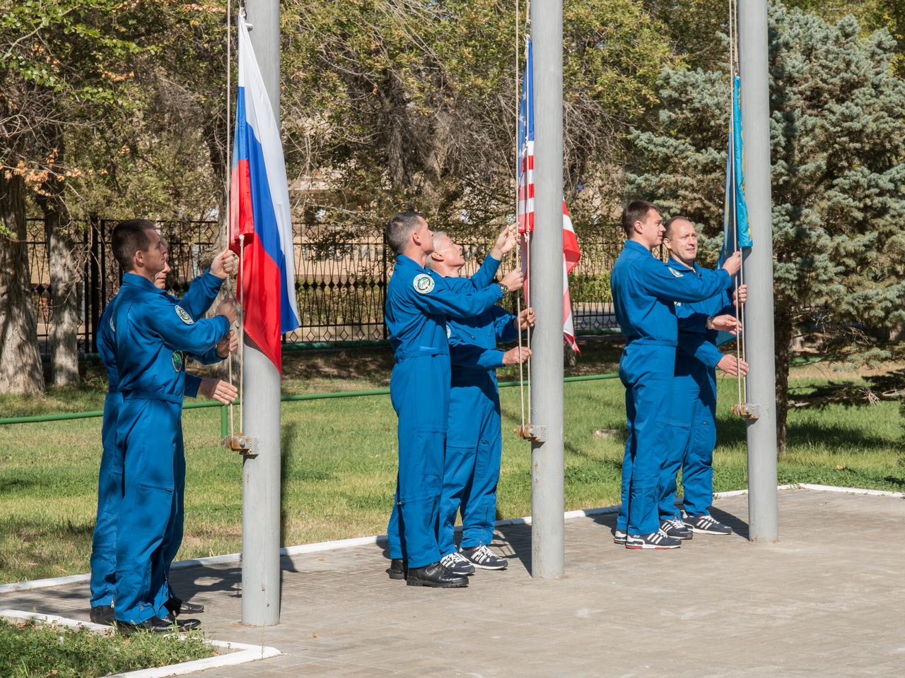 At their Cosmonaut Hotel crew quarters in Baikonur, Kazakhstan, the Expedition 49 prime and backup crewmembers participate in a traditional ceremony Sept. 10 to raise the flags of the U.S., Russia and Kazakhstan. Shane Kimbrough of NASA and Sergey Ryzhikov and Andrey Borisenko of Roscosmos will launch on Sept. 24, Kazakh time from the Baikonur Cosmodrome in Kazakhstan on the Soyuz MS-02 vehicle for a five-month mission on the International Space Station.  NASA/Victor Zelentsov 