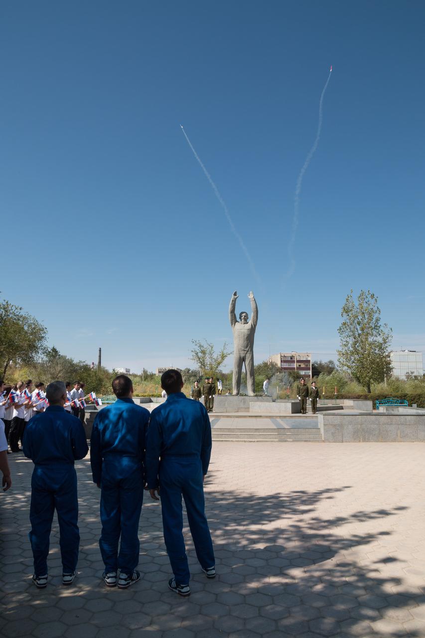 The Expedition 49 backup crewmembers watch an amateur rocket demonstration Sept. 10 by a statue of Yuri Gagarin, the first human to fly in space, during a tour of the city of Baikonur, Kazakhstan. They are serving as backups to Shane Kimbrough of NASA and Sergey Ryzhikov and Andrey Borisenko of Roscosmos, who will launch on Sept. 24, Kazakh time from the Baikonur Cosmodrome in Kazakhstan on the Soyuz MS-02 vehicle for a five-month mission on the International Space Station. NASA/Victor Zelentsov