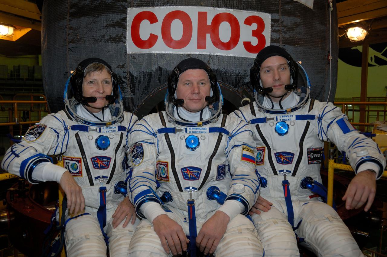 In the Integration Facility at the Baikonur Cosmodrome in Kazakhstan, Expedition 50-51 crewmembers Peggy Whitson of NASA (left), Oleg Novitskiy of the Russian Federal Space Agency (Roscosmos, center) and Thomas Pesquet of the European Space Agency (right) pose for pictures Nov. 2 in front of their Soyuz MS-03 spacecraft during a fit check dress rehearsal. They will launch Nov. 18, Baikonur time, for a six-month mission on the International Space Station. NASA/Alexander Vysotsky