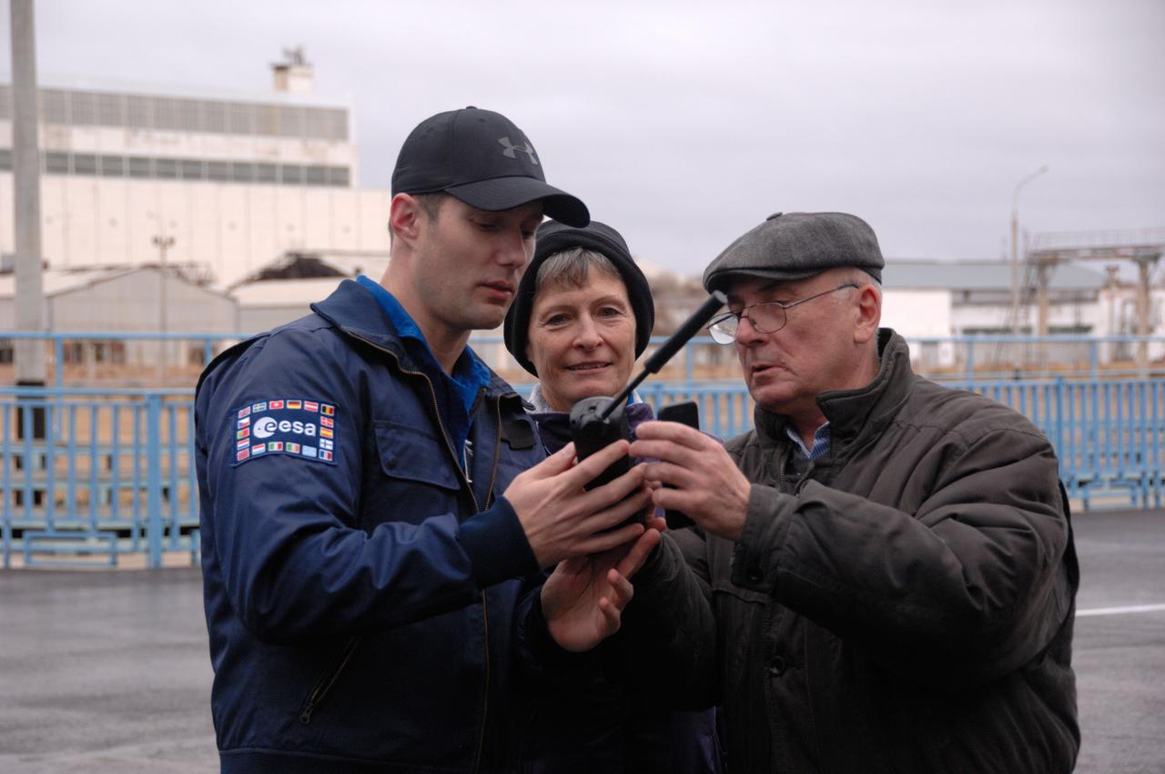 Outside the Integration Facility at the Baikonur Cosmodrome in Kazakhstan, Expedition 50-51 crewmembers Thomas Pesquet of the European Space Agency (left) and Peggy Whitson of NASA (center) take lessons from an unidentified Russian technician on the use of a satellite phone Nov. 2 during pre-launch training. Whitson, Pesquet and Oleg Novitskiy of the Russian Federal Space Agency (Roscosmos) will launch Nov. 18, Baikonur time, on the Soyuz MS-03 spacecraft for a six-month mission on the International Space Station. NASA/Alexander Vysotsky