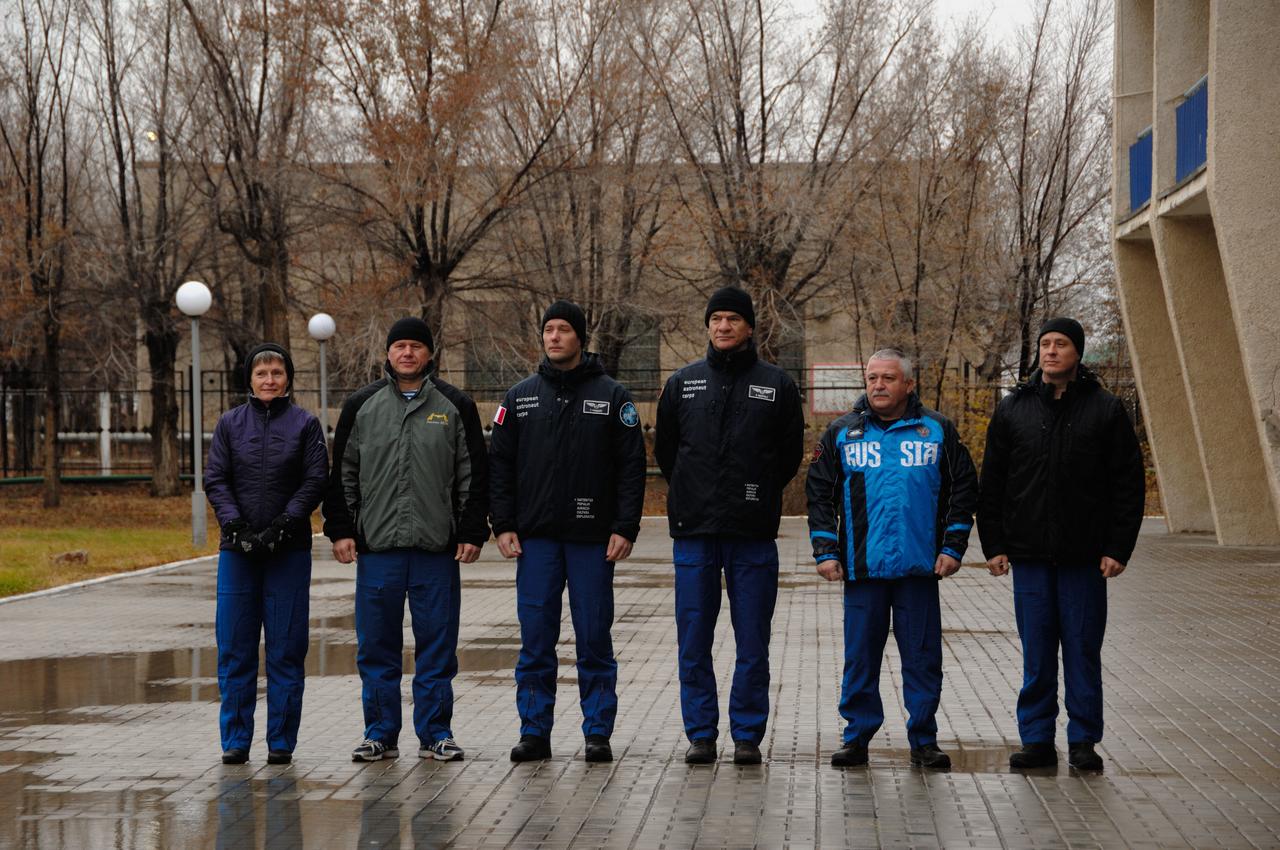 Under leaden skies outside their Cosmonaut Hotel crew quarters in Baikonur, Kazakhstan, the Expedition 50 prime and backup crewmembers pose for photos Nov. 3 during their traditional flag-raising ceremony. From left to right are prime crewmembers Peggy Whitson of NASA, Oleg Novistkiy of the Russian Federal Space Agency (Roscosmos) and Thomas Pesquet of the European Space Agency and backup crewmembers Paolo Nespoli of the European Space Agency, Fyodor Yurchikhin of Roscosmos and Jack Fischer of NASA. Whitson, Novitskiy and Pesquet will launch Nov. 18, Baikonur time, on the Soyuz MS-03 spacecraft for a six-month mission on the International Space Station. NASA/Alexander Vysotsky