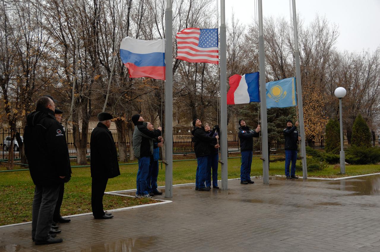 Under leaden skies outside their Cosmonaut Hotel crew quarters in Baikonur, Kazakhstan, the Expedition 50 prime and backup crewmembers raise the flags of Russia, the U.S., France and Kazakhstan Nov. 3 during their traditional ceremony. Peggy Whitson of NASA, Oleg Novistkiy of the Russian Federal Space Agency (Roscosmos) and Thomas Pesquet of the European Space Agency will launch Nov. 18, Baikonur time, on the Soyuz MS-03 spacecraft for a six-month mission on the International Space Station.  NASA/Alexander Vysotsky 