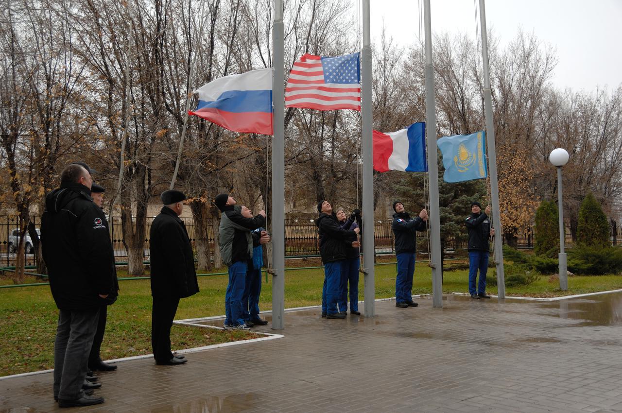 Under leaden skies outside their Cosmonaut Hotel crew quarters in Baikonur, Kazakhstan, the Expedition 50 prime and backup crewmembers raise the flags of Russia, the U.S., France and Kazakhstan Nov. 3 during their traditional ceremony. Peggy Whitson of NASA, Oleg Novistkiy of the Russian Federal Space Agency (Roscosmos) and Thomas Pesquet of the European Space Agency will launch Nov. 18, Baikonur time, on the Soyuz MS-03 spacecraft for a six-month mission on the International Space Station.  NASA/Alexander Vysotsky 