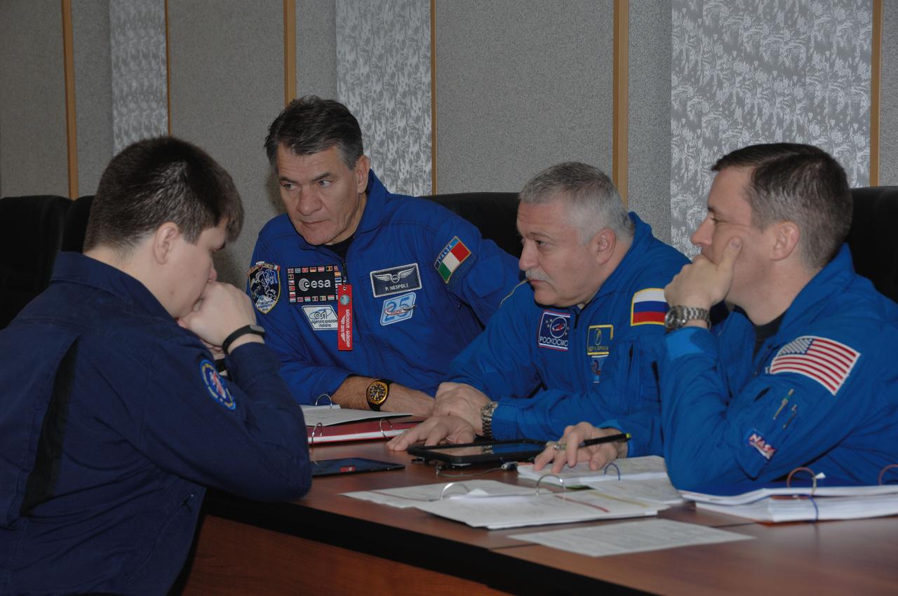 At their Cosmonaut Hotel crew quarters in Baikonur, Kazakhstan, Expedition 50-51 backup crewmembers Paolo Nespoli of the European Space Agency (left), Fyodor Yurchikhin of the Russian Federal Space Agency (Roscosmos, center) and Jack Fischer of NASA (right) review flight plans with trainers Nov. 10 as part of preflight activities. They are backups to the prime crewmembers, Peggy Whitson of NASA, Oleg Novitskiy of Roscosmos and Thomas Pesquet of the European Space Agency, who will launch Nov. 18, Baikonur time, on the Soyuz MS-03 spacecraft for a six-month mission on the International Space Station. NASA/Alexander Vysotsky
