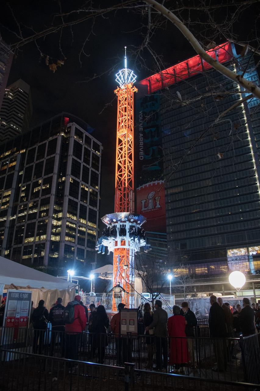 jsc2017e011279 (01/27/2017) --- Crowds of visitors line up for the NASA Orion Journey to Mars ride at the Houston Texas NFL Live Super Bowl LI event on Discovery Green Jan. 27, 2017. With people safely seated and virtual googles in place the ride pulls the Orion capsule up 90 feet then drops them suddenly to the bottom providing a physical experience as well as a visual one while experiencing the trip to Mars and back. The virtual reality trip is a popular no cost feature as part of NASA’s Future Flight area which also houses many other NASA space exploration and science exhibits. NASA PHOTOGRAPHER: Robert Markowitz