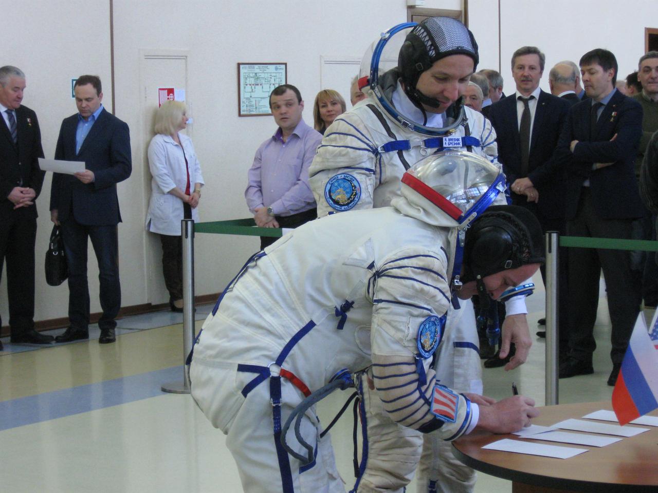 jsc2017e038542 (March 30, 2017) --- At the Gagarin Cosmonaut Training Center in Star City, Russia, Expedition 51 backup crewmember Sergey Ryazanskiy of the Russian Federal Space Agency (Roscosmos, left) signs in for the start of final crew qualification exams March 30 as his crewmate, Randy Bresnik of NASA (right) looks on. They are backups to Fyodor Yurchikhin of Roscosmos and Jack Fischer of NASA, who will launch April 20 on the Soyuz MS-04 spacecraft from the Baikonur Cosmodrome in Kazakhstan for a four and a half month mission on the International Space Station. Credit: NASA/Rob Navias