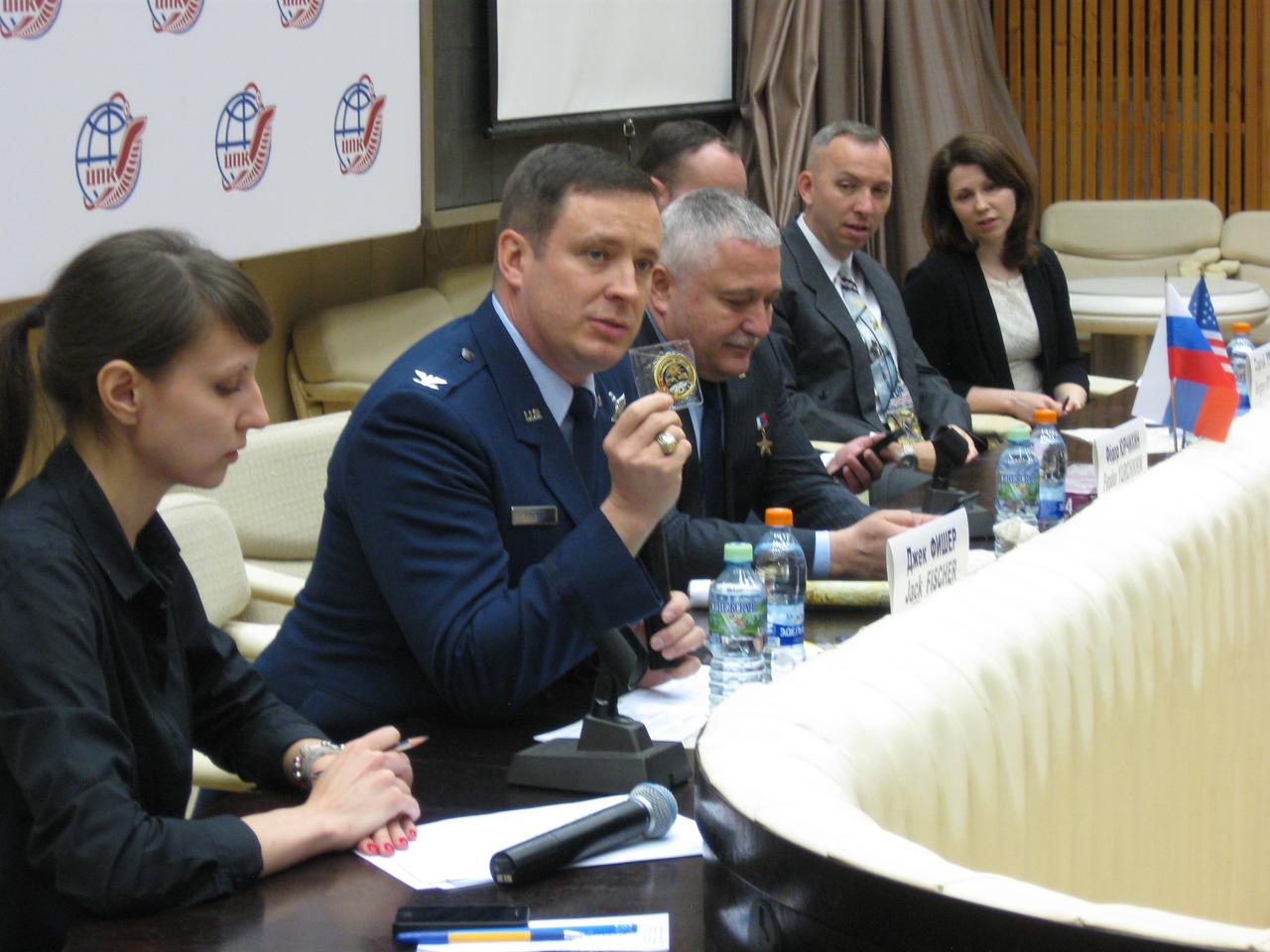 jsc2017e039445 (04/03/2017) --- At the Gagarin Cosmonaut Training Center in Star City, Russia, Expedition 51 crewmember Jack Fischer of NASA displays a medal derived from the Apollo-Soyuz crew patch during a news conference April 3 to demonstrate how the U.S. and Russia are continuing their cooperation in space exploration. To Fischer’s left is crewmate Fyodor Yurchikhin of the Russian Federal Space Agency (Roscosmos). They will launch April 20 on the Soyuz MS-04 spacecraft from the Baikonur Cosmodrome in Kazakhstan for a four and a half month mission on the International Space Station. Photo: NASA/Rob Navias.