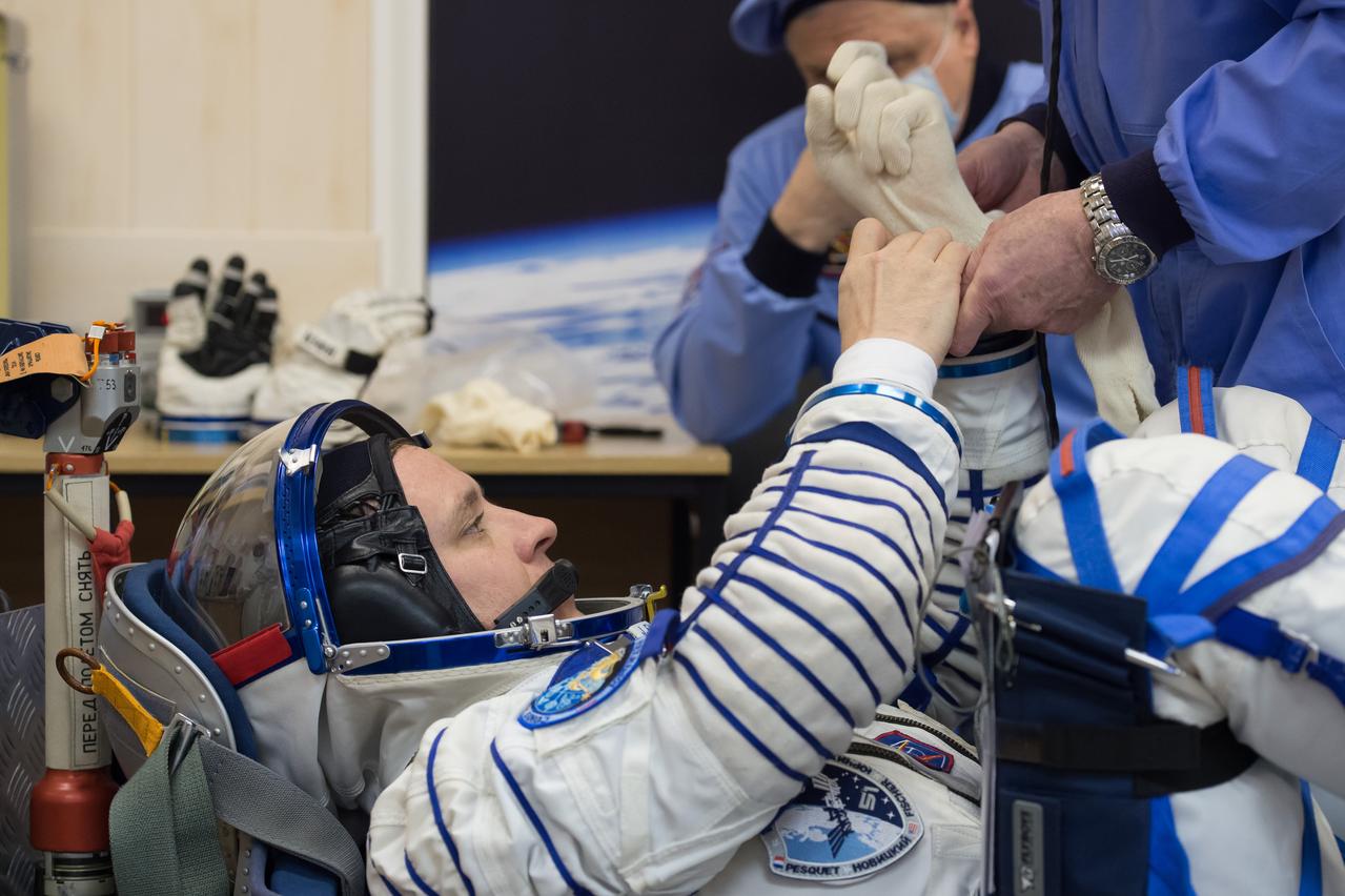 jsc2017e040287 (April 6, 2017) --- In the Integration Building at the Baikonur Cosmodrome in Kazakhstan, Expedition 51 crewmember Jack Fischer of NASA slips into the gloves of his Russian Sokol launch and entry suit April 6 prior to climbing aboard the Soyuz MS-04 spacecraft as part of pre-launch preparations. Fischer and Fyodor Yurchikhin of the Russian Federal Space Agency (Roscosmos) will launch April 20 on the Soyuz MS-04 spacecraft for a four and a half month mission on the International Space Station. NASA/Gagarin Cosmonaut Training Center/Andrey Shelepin