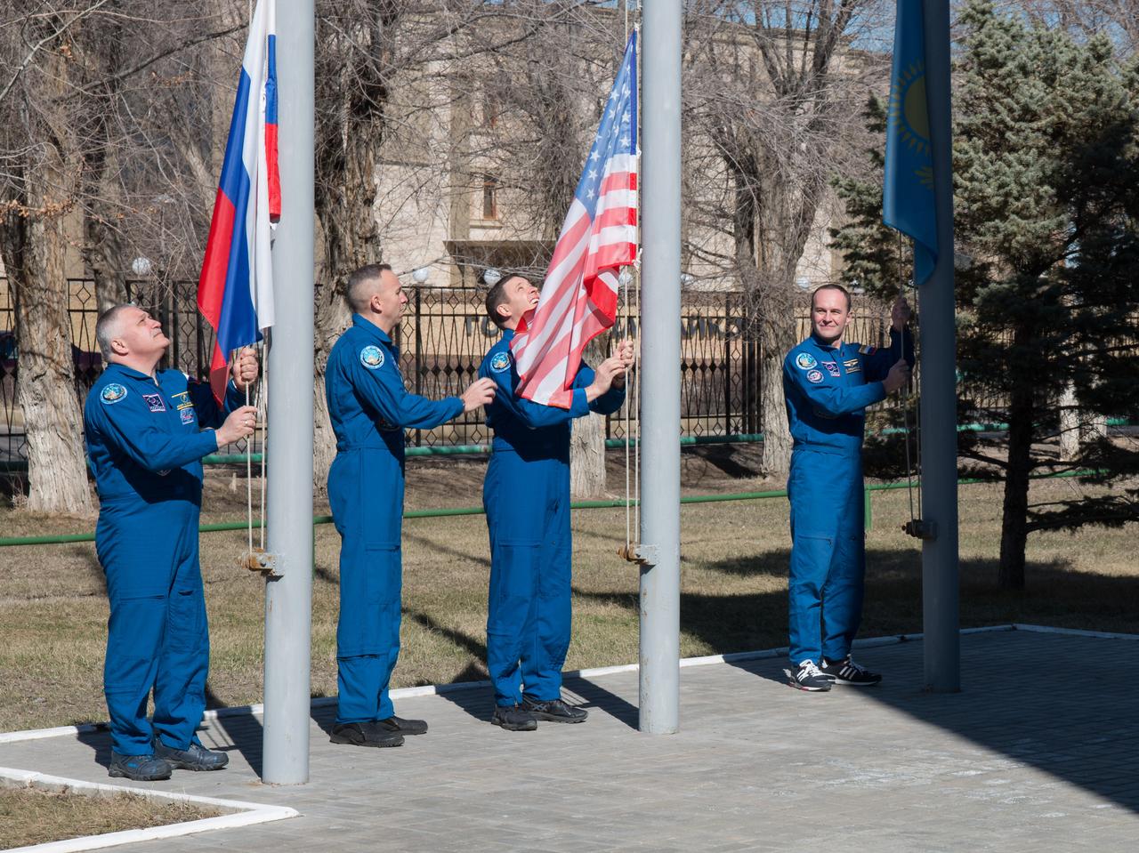 jsc2017e040340 (April 7, 2017) --- At the Cosmonaut Hotel crew quarters in Baikonur, Kazakhstan, the Expedition 51 prime and backup crewmembers raise the flags of Russia, the U.S. and Kazakhstan in traditional ceremonies April 7 as part of their pre-launch activities. From left to right are prime crewmember Fyodor Yurchikhin of the Russian Federal Space Agency (Roscosmos) raising the Russian flag, backup crewmember Randy Bresnik of NASA joining prime crewmember Jack Fischer of NASA to raise the American flag and backup crewmember Sergey Ryazanskiy of Roscosmos raising the Kazakh flag. Yurchikhin and Fischer will launch April 20 on the Soyuz MS-04 spacecraft from the Baikonur Cosmodrome for a four and a half month mission on the International Space Station. NASA/Victor Zelentsov