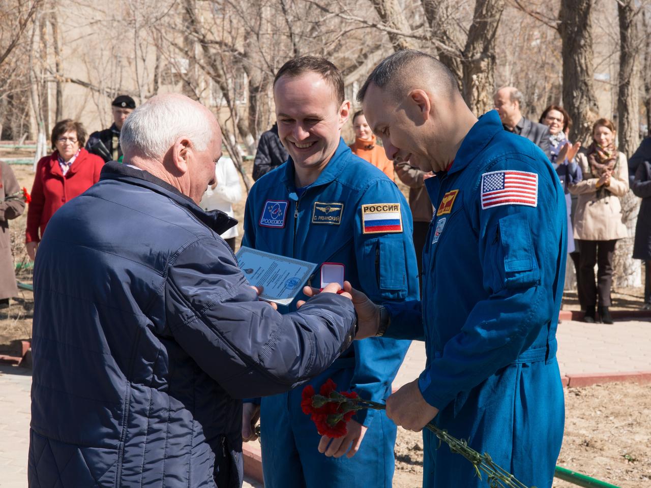 jsc2017e040342 (April 7, 2017) --- Expedition 51 backup crewmembers Sergey Ryazanskiy of the Russian Federal Space Agency (Roscosmos, center) and Randy Bresnik of NASA (right) accept commemorative items from a local official in Baikonur, Kazakhstan April 7 as part of traditional pre-launch activities. They are serving as backups to Fyodor Yurchikhin of Roscosmos and Jack Fischer of NASA, who will launch April 20 on the Soyuz MS-04 spacecraft from the Baikonur Cosmodrome for a four and a half month mission on the International Space Station. NASA/Victor Zelentsov